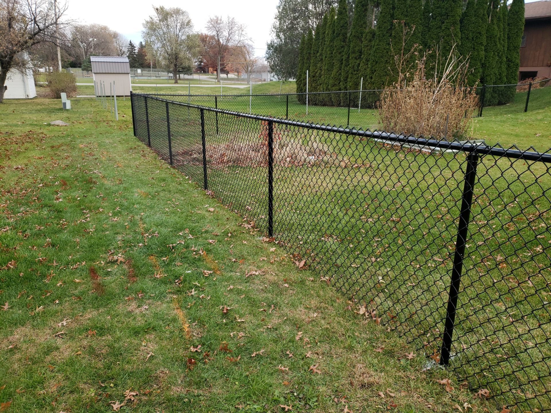 Residential Black Vinyl-Coated Chain Link Fence in Grundy Center by Perfect Picket Fence and Stain
