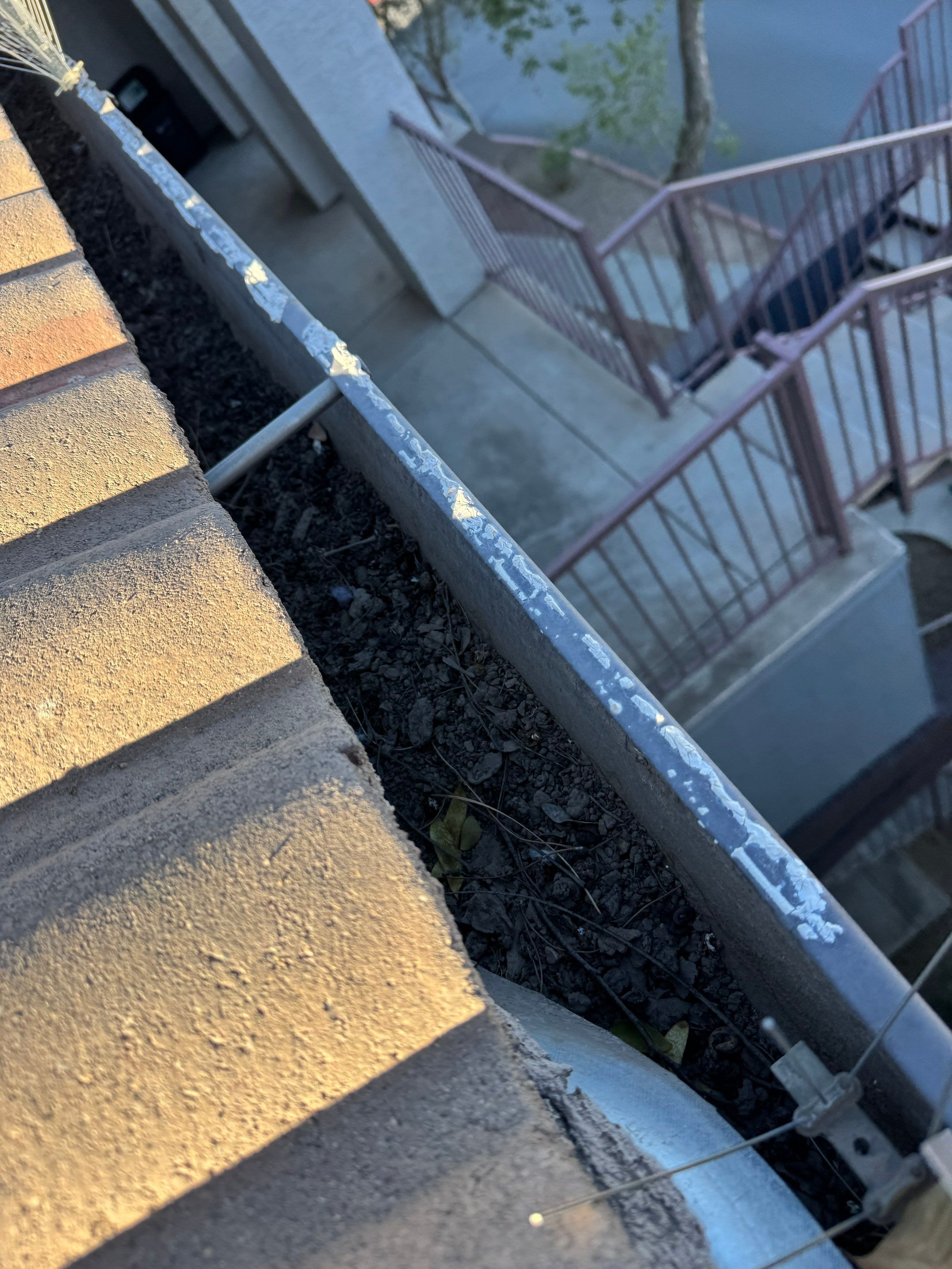Commercial gutter cleaning Surprise & Goodyear, AZ before photo with filled gutters