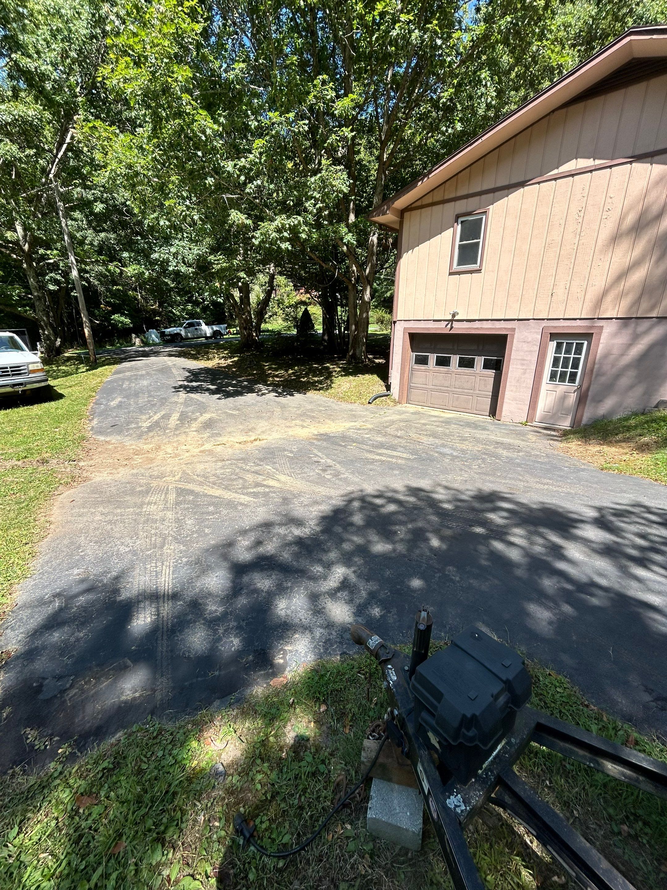 cleaning and restoring the asphalt driveway to remove dirt and stains for better appearance and maintenance