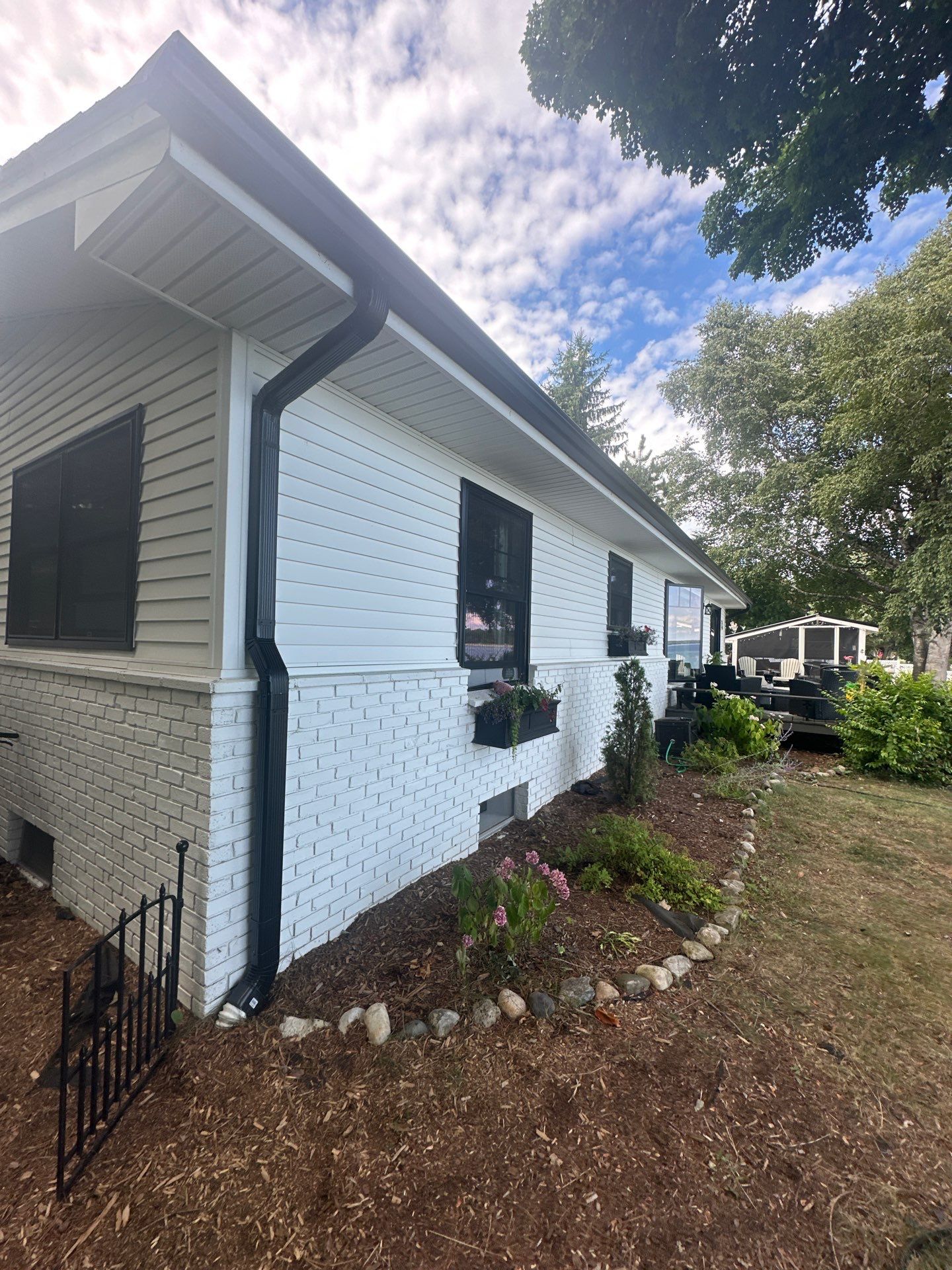 Black Gutter and Gutter Helmet Installation for Suttons Bay Home by Rainbow Seamless Systems