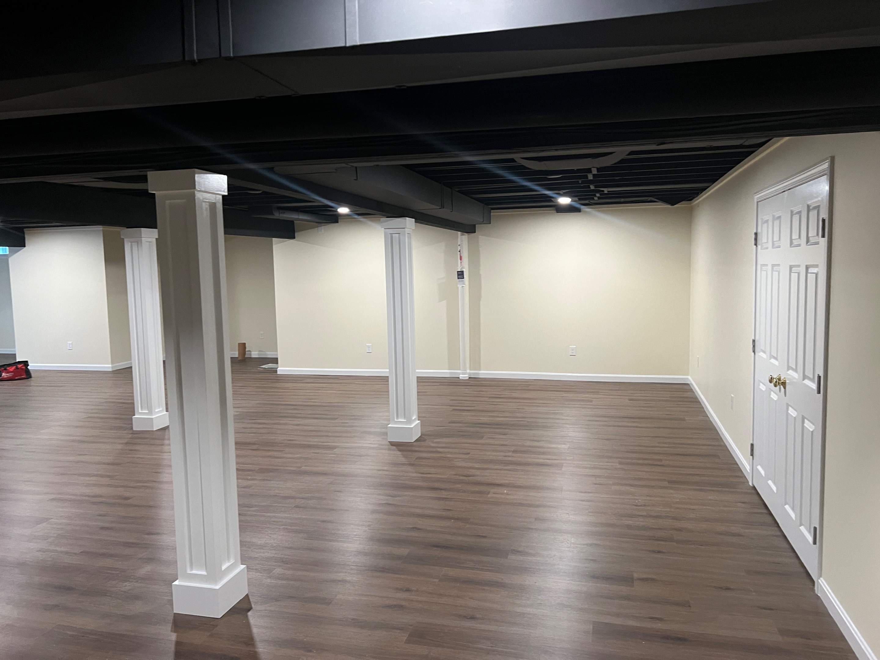 Basement Remodel w/ LVP Flooring & Exposed Ceiling by Chagnon Building & Remodeling LLC