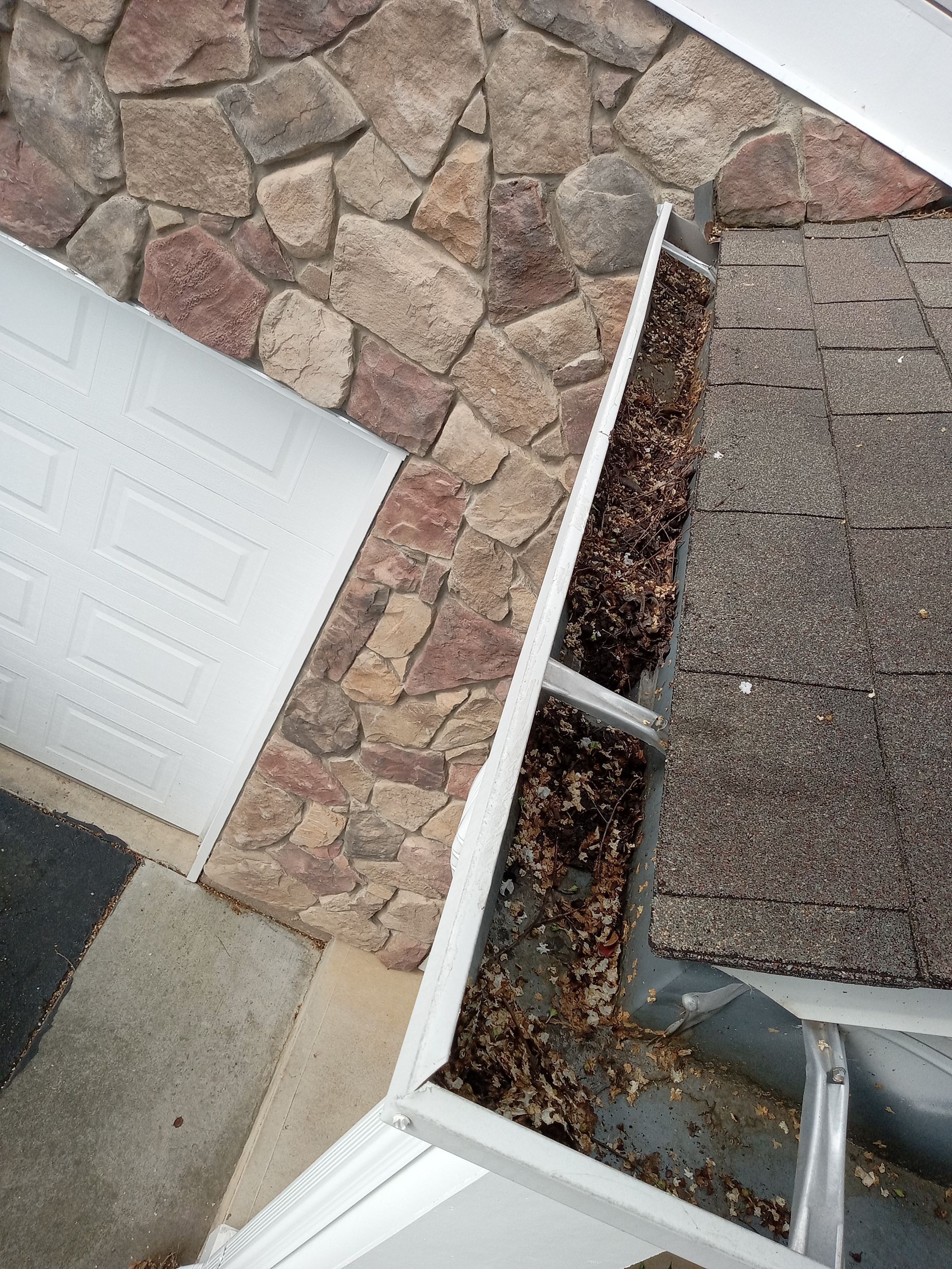 HOA gutter cleaning in Cumming & Forsyth County, GA,before  photo showing full gutters.