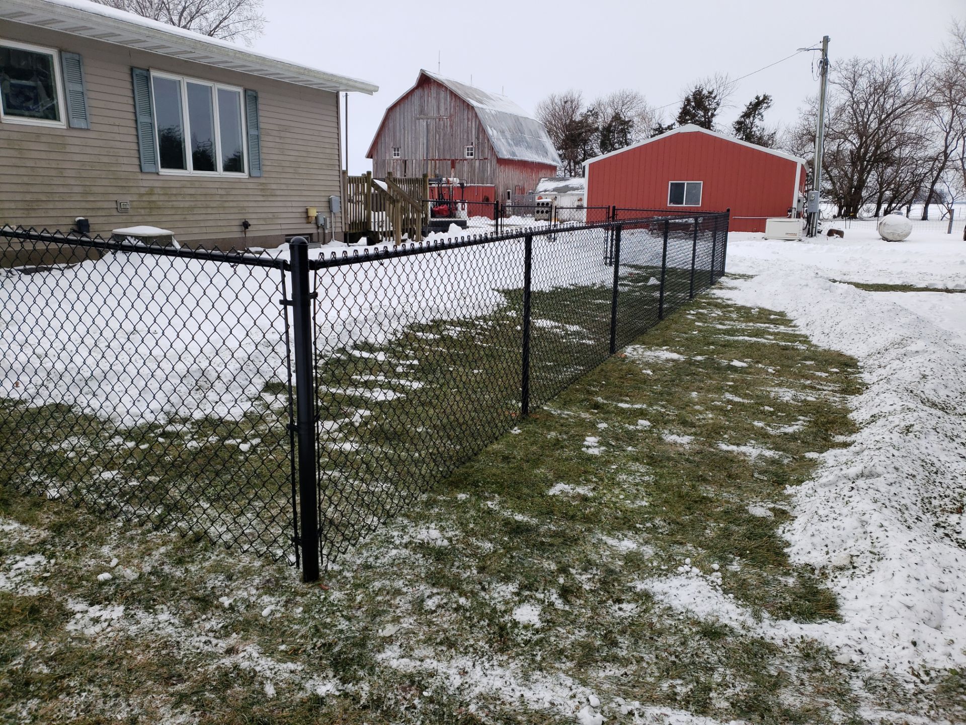 Black Vinyl-Coated Chain Link Fence Installation in Oelwein by Perfect Picket Fence and Stain