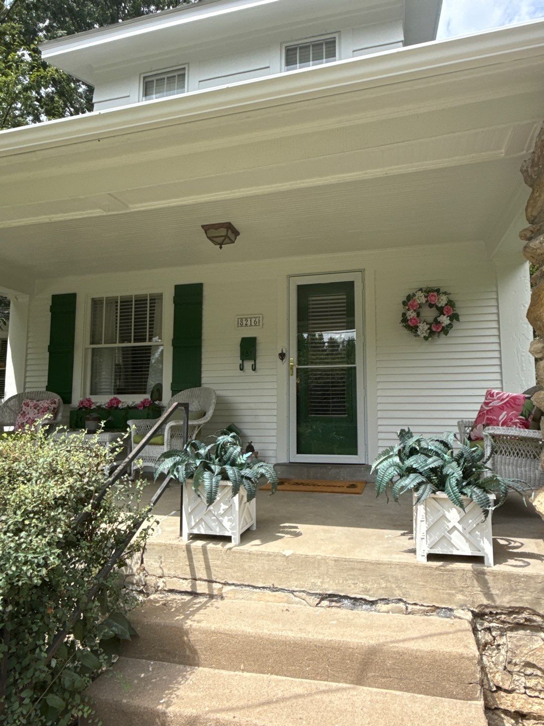 This 100-year-old home shines with a fresh coat of Spare White, bold Arugula accents on the front door and shutters, and a warm Fired Brick deck for timeless curb appeal. by Cougar Painting