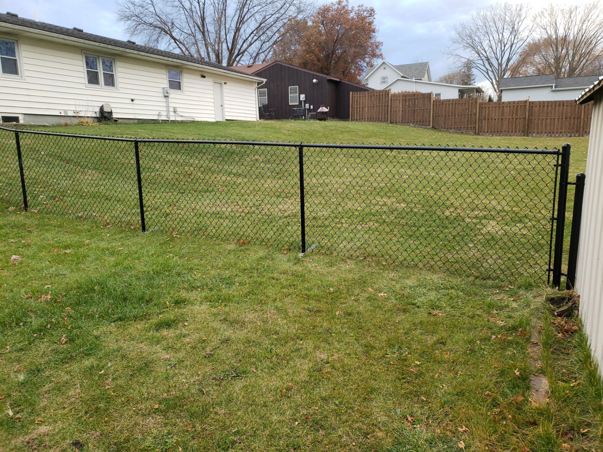 Residential Black Vinyl-Coated Chain Link Fence in Grundy Center by Perfect Picket Fence and Stain