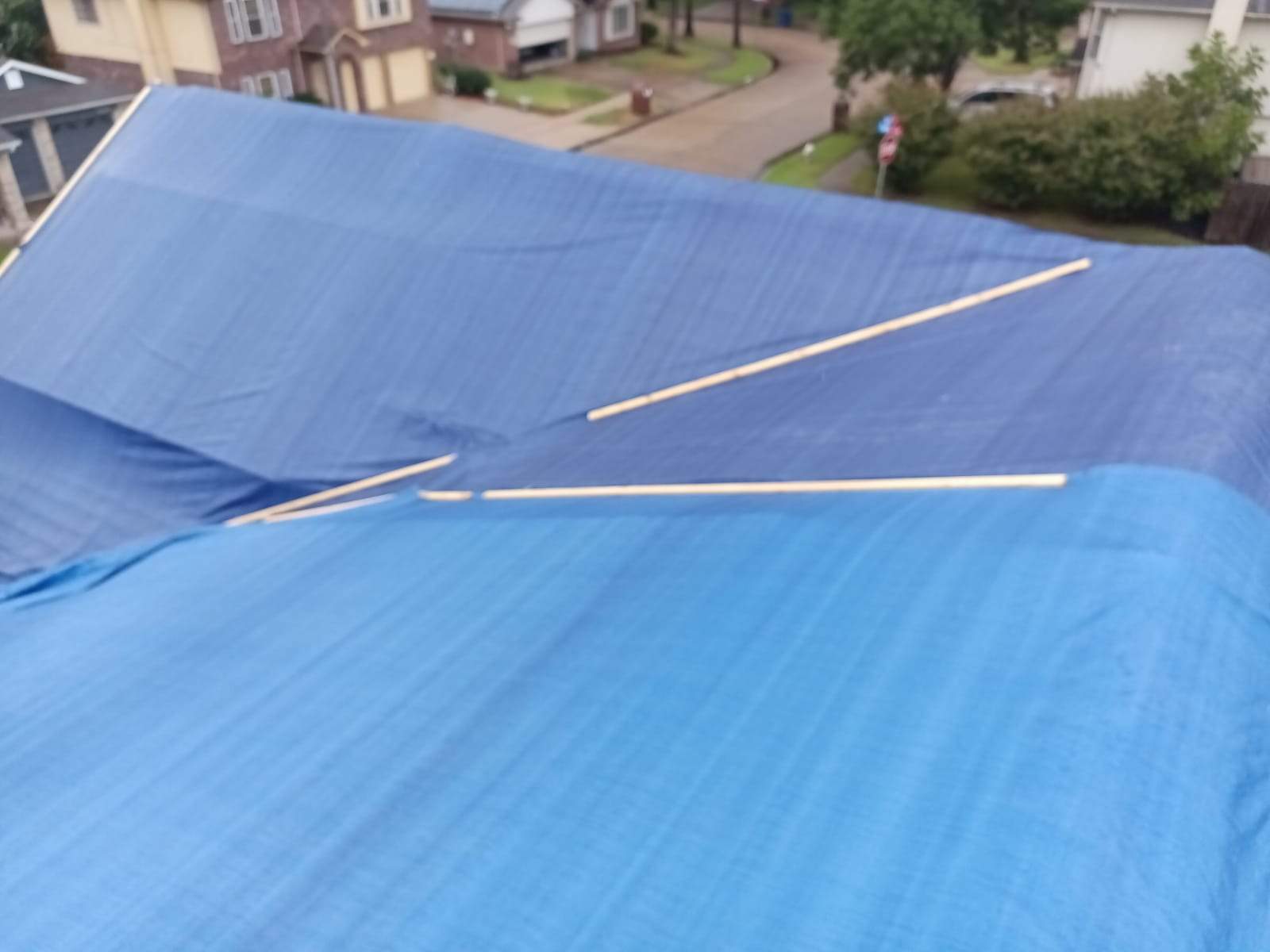 Placement of tarps on the roof. using TARP BLUE by V General Contractors 