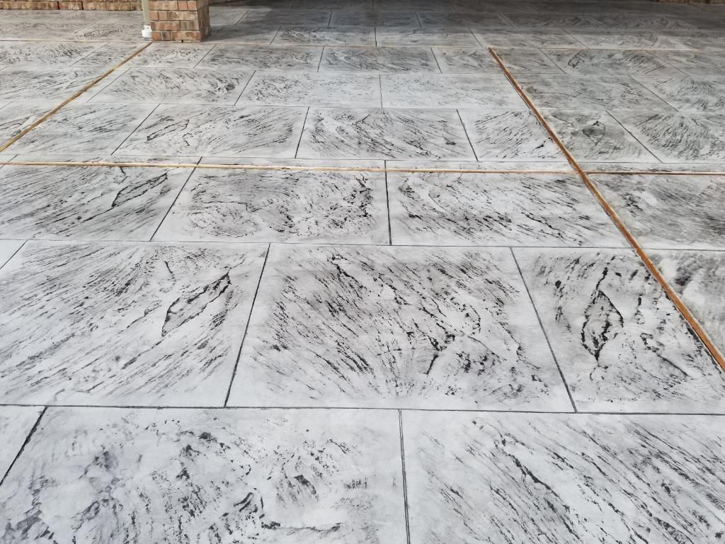 Major Transformation Project: Retaining Wall, Patio, and Drainage for Mr. & Mrs. Veerman! 🤩🛠️ We recently completed a comprehensive, custom project for Mr. & Mrs. Veerman that was all about structure, stability, and stunning outdoor design! This was a multi-phased project requiring the expertise of our Master Handcrafted Team.  Phase 1: Foundation and Water Management A successful outdoor space starts beneath the surface. We focused heavily on preparation and protection:  Demolition & Grading: We professionally removed and disposed of old dirt to achieve a level surface, ensuring the entire area was leveled and graded to enhance both appearance and functionality.  Comprehensive Drainage System: To prevent water issues and protect the new construction, we installed a complete system, connecting existing downspout gutters to channel drainage and strategically placed catch basins around the patio area.  Robust Concrete Foundation: Expert framing led to the pouring of a 4-inch deep, high PSI concrete slab to create a robust and lasting foundation for the entire retaining wall area.  Phase 2: Handcrafted Structure and Style This phase brought in our masonry and carpentry artisans to build the defining elements of the new space:  Custom Retaining Wall: Our master handcrafted team built a stunning, structural retaining wall. This involved careful framing, precise concrete work, and meticulous masonry construction with vertical supports every 3 feet for maximum stability.  Client Involvement: Mr. & Mrs. Veerman played a key role in selecting the retainer wall fascia and stone materials, ensuring the final look perfectly matched their vision.  Stamped Concrete Patio: We installed a beautiful stamped concrete patio. This decorative concrete work involved imprinting a pattern into the fresh concrete, giving them the high-end look of stone or brick with the durability of concrete.  Walk Add-On: Extended the stamped concrete to include a new, seamless walk area.  (Optional) Custom Garden Box: Constructed durable, raised garden boxes using 2"x12" boards and strong 4"x6" posts.  Phase 3: Landscaping and Finishing Touches The final details bring the entire project to life, focusing on irrigation and planting:  Sprinkler System Upgrade: To support their new landscaping, we upgraded their irrigation system by installing two new drip zones and a new control unit.  Flower Beds: Integrated new flower beds along the retaining wall and patio, ready for planting.  Decoration: Concluded the project with personalized decoration options to perfectly complement their beautiful, newly structured space.  Thinking About a Multi-Layered Outdoor Project? This project demonstrates our ability to seamlessly handle complex jobs—from heavy-duty drainage and structural construction to decorative finishes and irrigation.  The proposed timeline for this extensive project was 10 to 15 working days!  ❓ Do you have a sloping yard or drainage issues that could be solved with a functional and beautiful retaining wall? Tell us your challenge! 👇  💡 We specialize in bringing intricate outdoor visions to life! If you're looking for a team with master craftsmen for your next patio, retaining wall, or full landscape overhaul, let's talk. by Texas Urban Elements