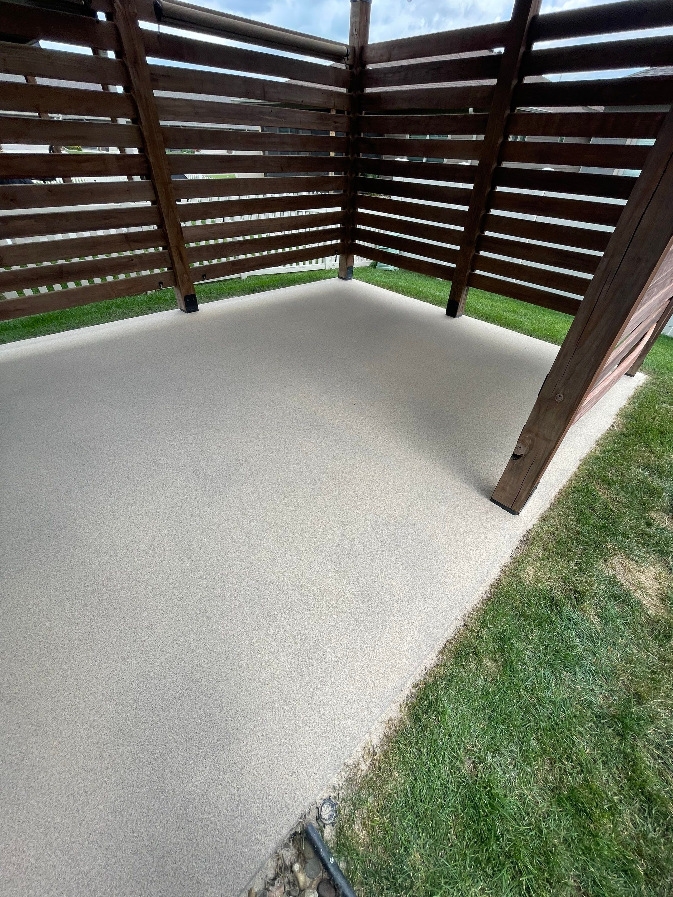 Textured Concrete Patio Coating and Custom Privacy Pergola in Sioux Falls by Select Painting, Coatings & Garage Cabinets