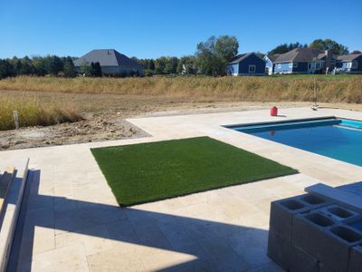 Custom Travertine Pool Deck with Artificial Turf Insets in Delaware