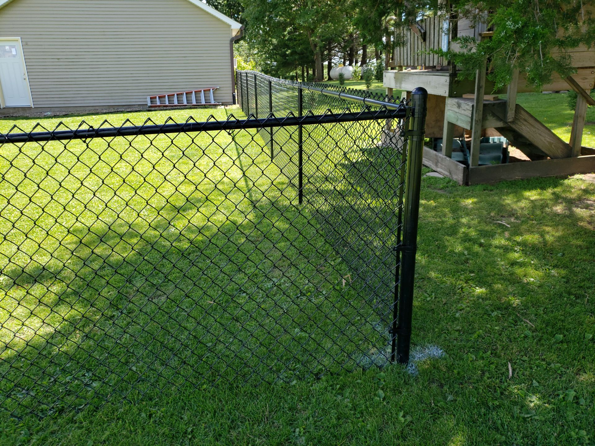 Residential Black Vinyl-Coated Chain Link Fence Installation in Bristow by Perfect Picket Fence and Stain