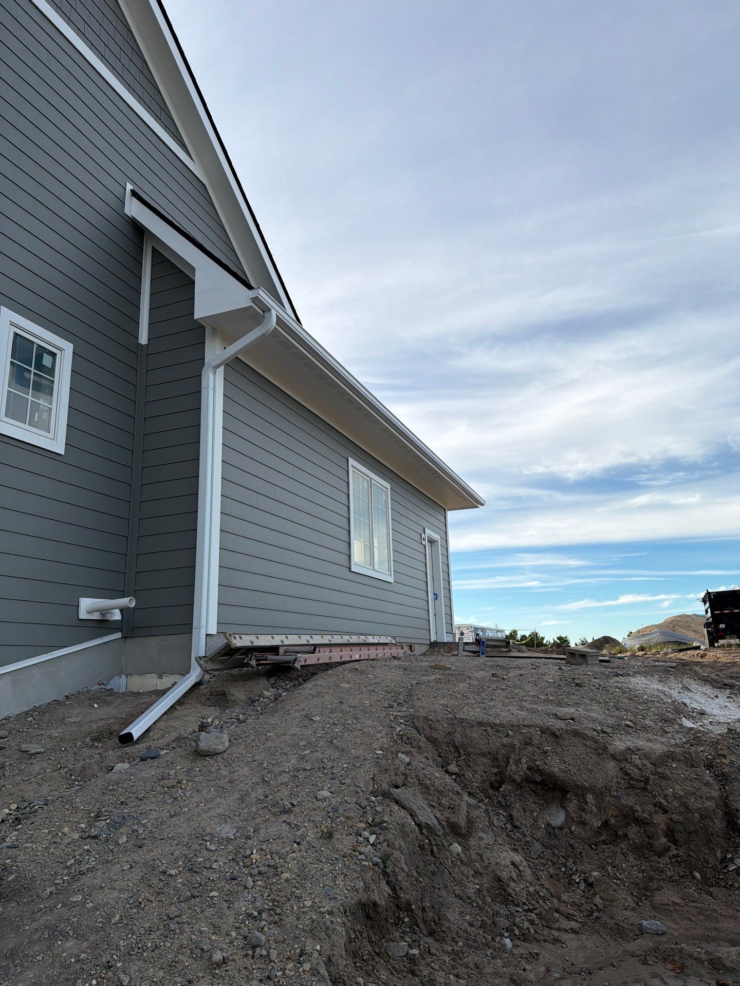 White Gutter and Downspout Installation for Petoskey New Build by Rainbow Seamless Systems