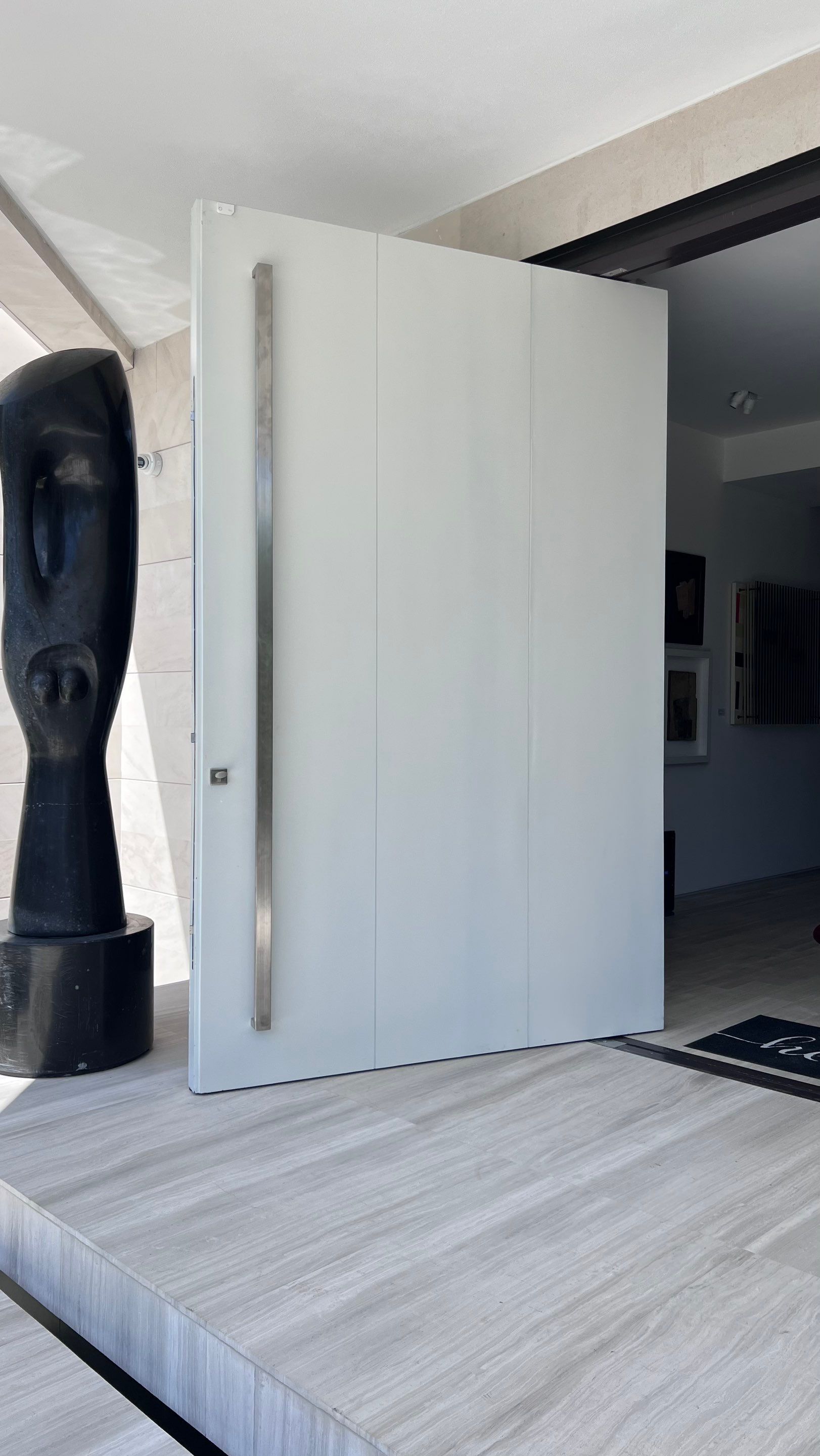 Custom Material Pivot Door installation by Impact Precious Wood Inc.