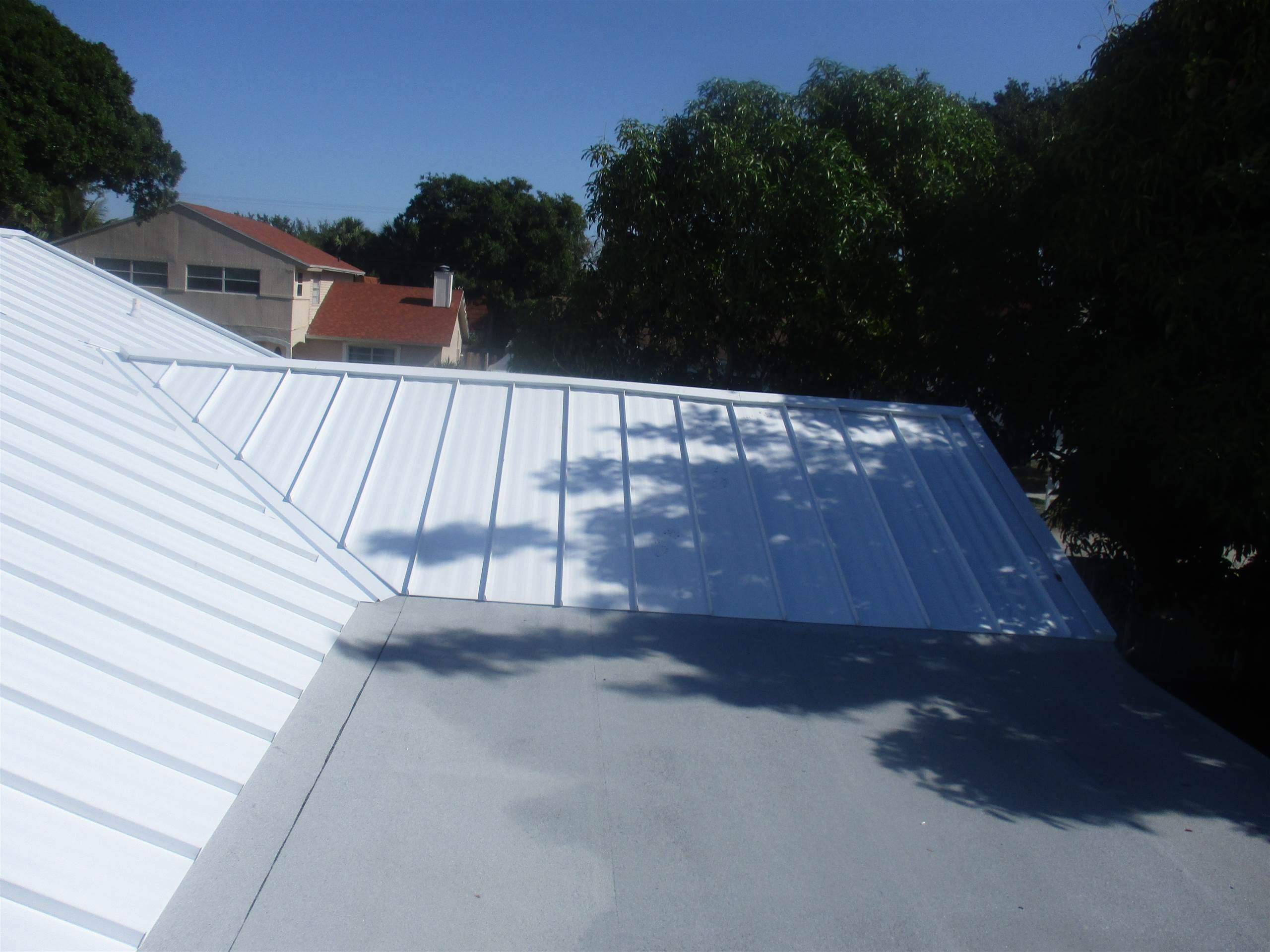 Standing Seam Metal & Flat Re-Roof using 1.5" Nail Strip 24ga Solar White Kynar Coated Standing Seam Metal Panels by Morton Roofing, Inc.