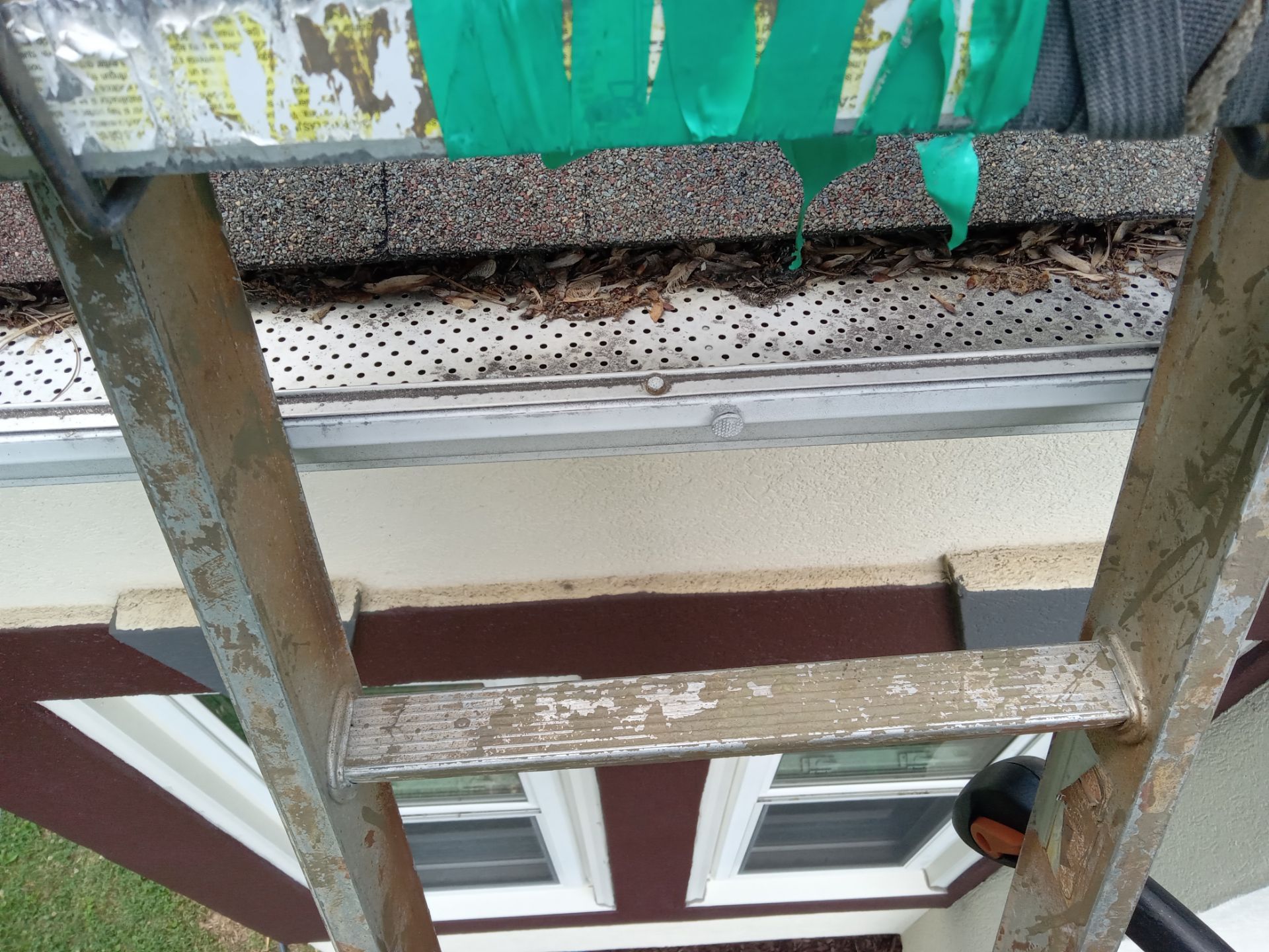 in the photo we see what appears to be the exterior of a house including a section of the gutter soffit and a window the ladder is positioned against the house suggesting that the cleaning service may be focusing on high areas like the gutter and soffit the gutters look as though they have some debris and accumulation which might be removed by pressure washing the soffit beneath the gutter also shows signs of dirt and possibly mildew which can be cleaned using a pressure washer services may also include cleaning the exterior of the windows and the window frames which often gather dust and grime over time pressure washing can help in restoring the appearance of these surfaces making them look clean and well-maintained