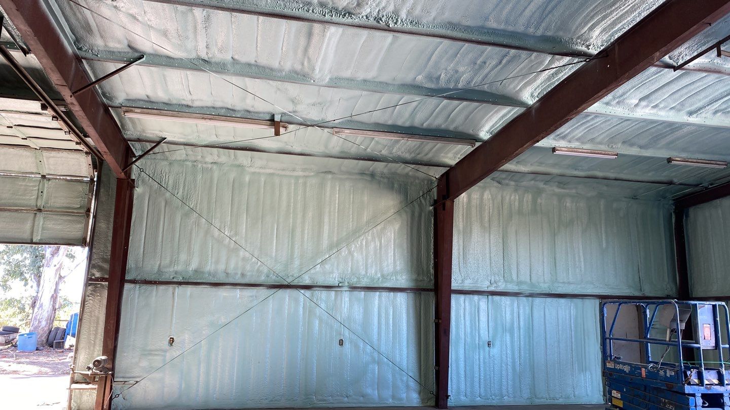 Spray foam insulation on inside of metal industrial building by Straight Edge Roofing Inc