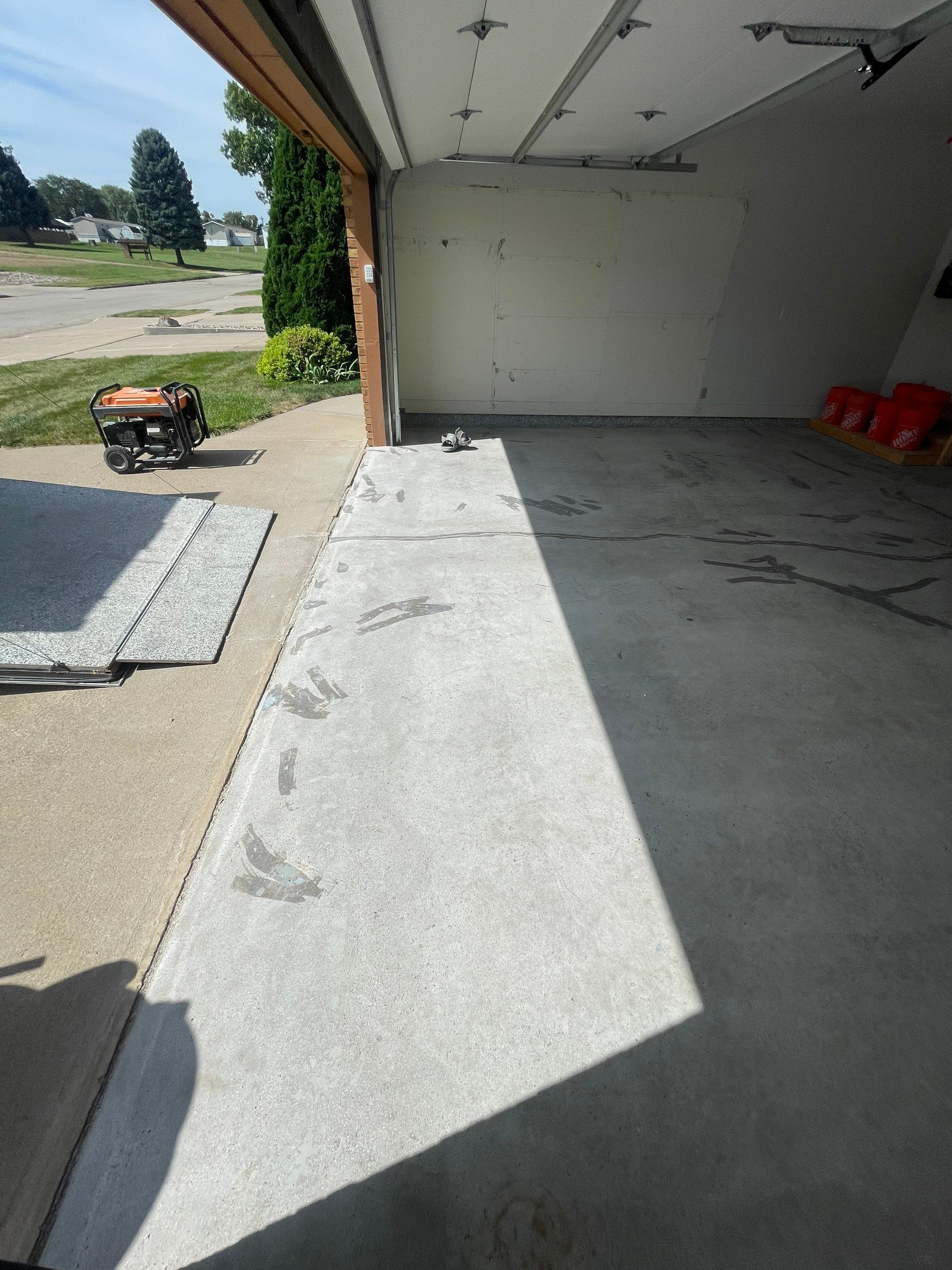 Grey Speckled Concrete Coating for Residential Garage in Yankton by Select Painting, Coatings & Garage Cabinets