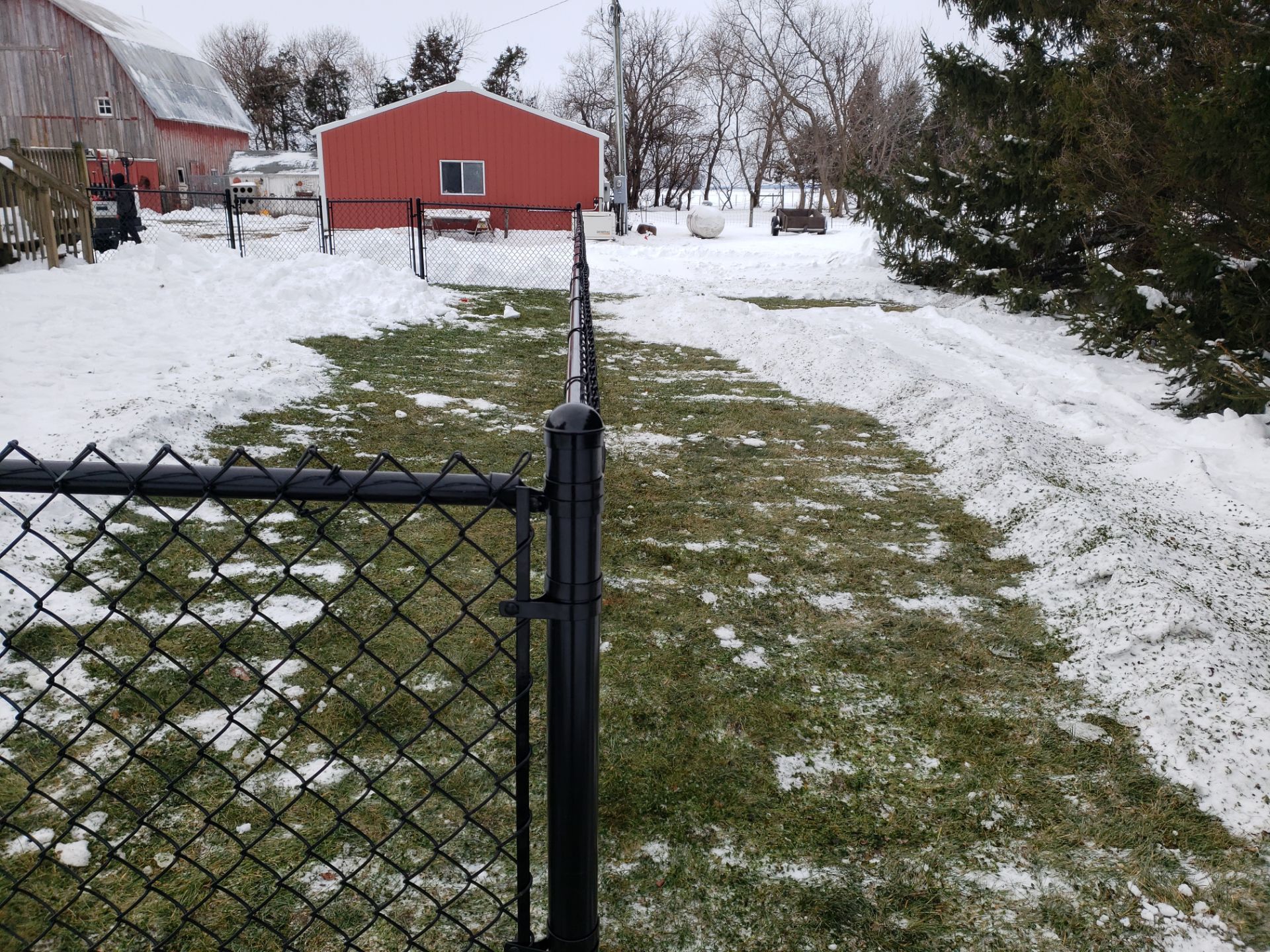 Black Vinyl-Coated Chain Link Fence Installation in Oelwein by Perfect Picket Fence and Stain