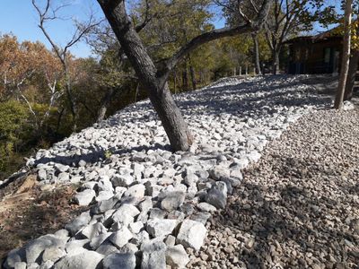 Supporting back of home with backfill at edge of steep creek