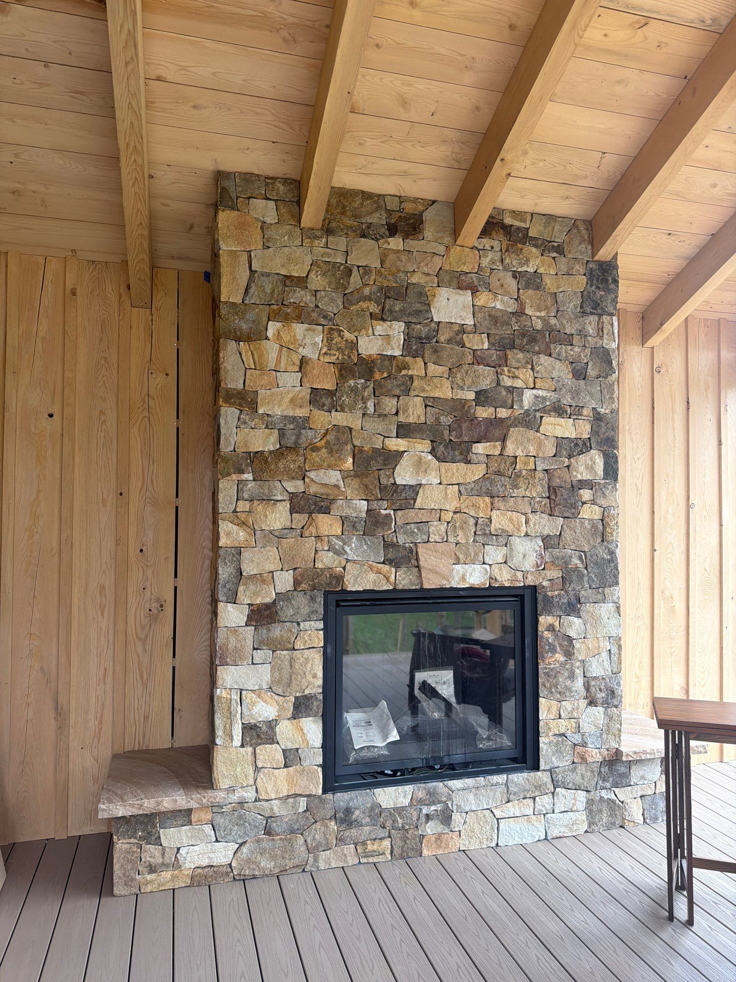 Custom Composite Deck with Stone Fireplace and Modern Cable Railing by Walnut Hollow Decks & Outdoor Living