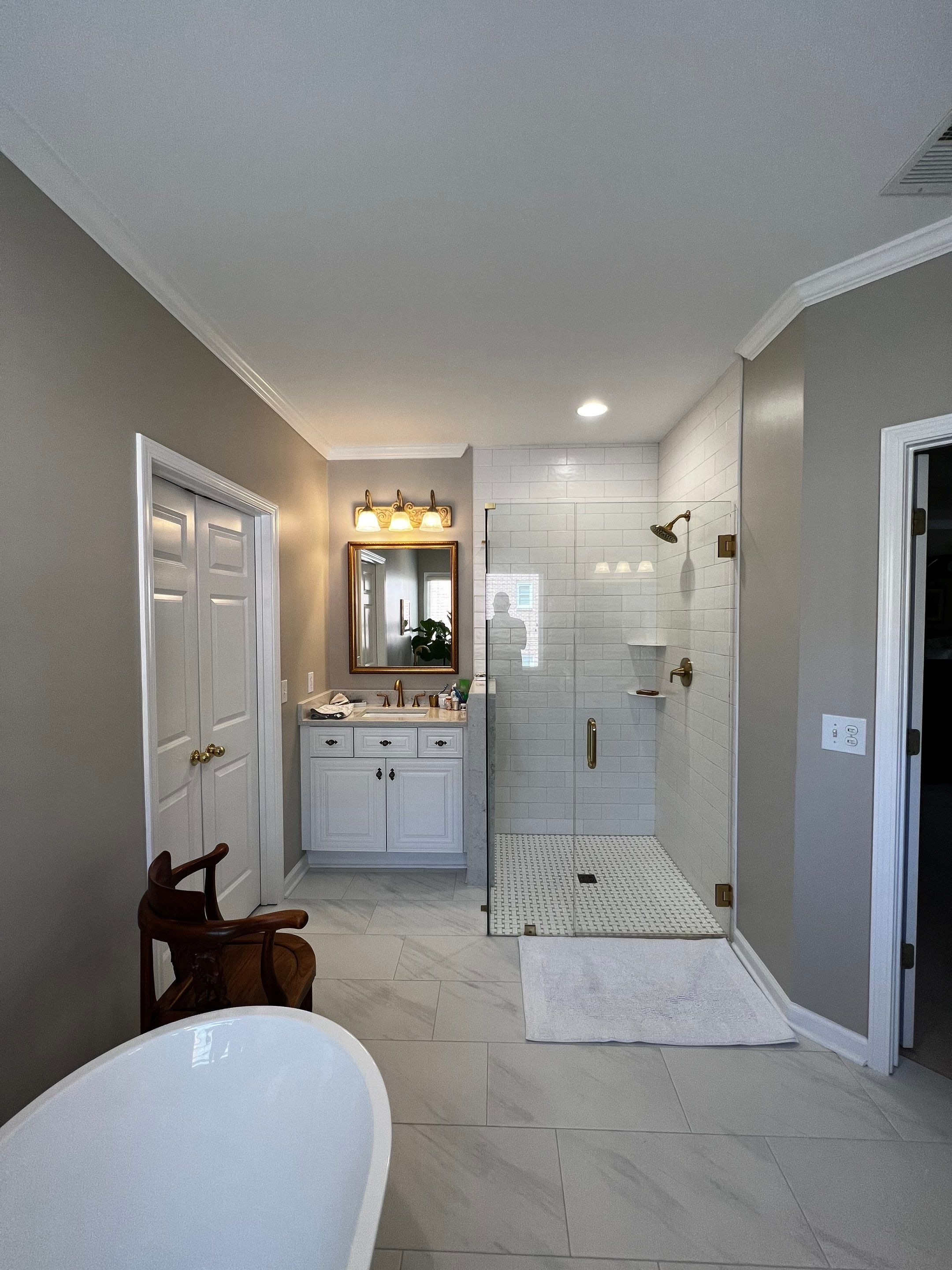 Master Bathroom Renovation with Marble Floor and Freestanding Soaking Tub by Swift Home Renovations