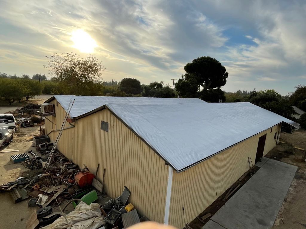 Metal roof sprayed with polyurethane spray foam and coatings by Straight Edge Roofing Inc