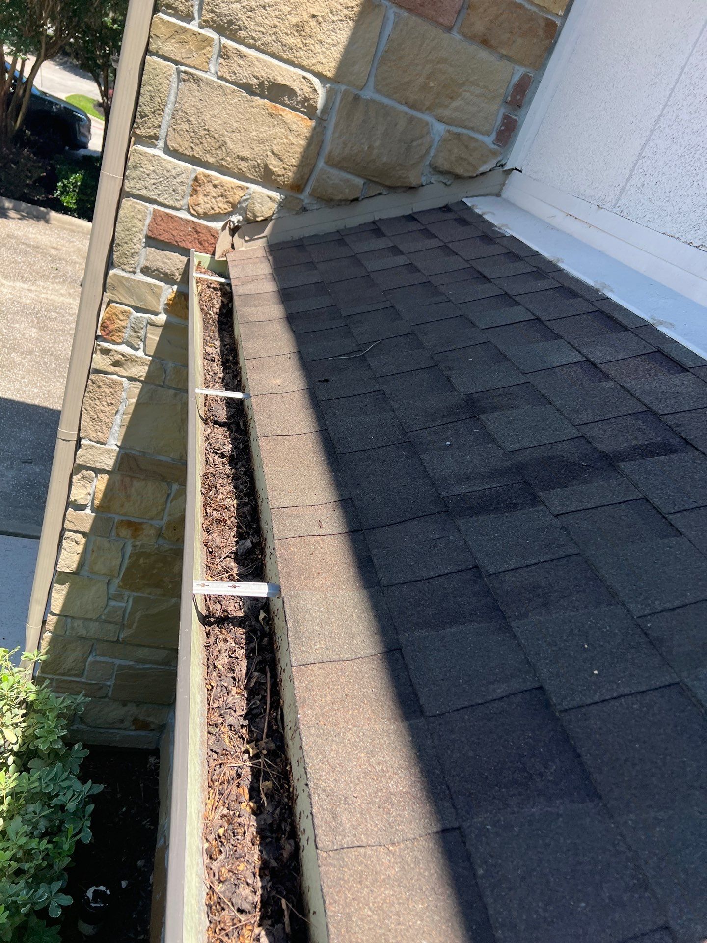 HOA gutter cleaning in League City & Webster,before  photo showing full gutters.