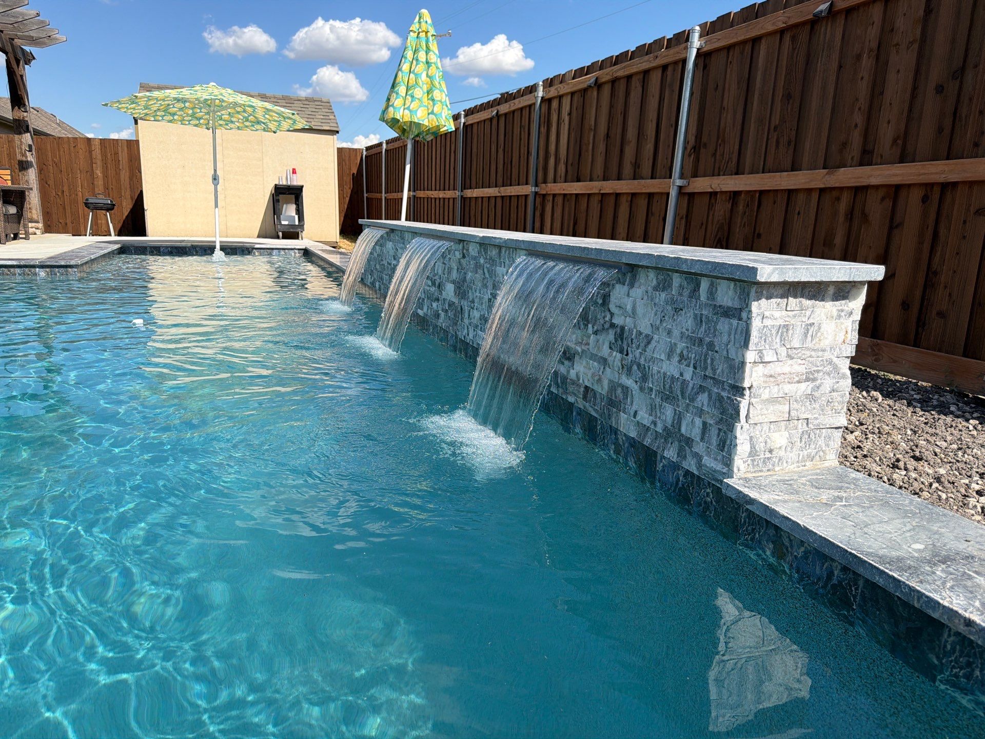 Geometric Pool with Raised Stone Waterfall Wall by Pinnacle Pools and Spas - DFW