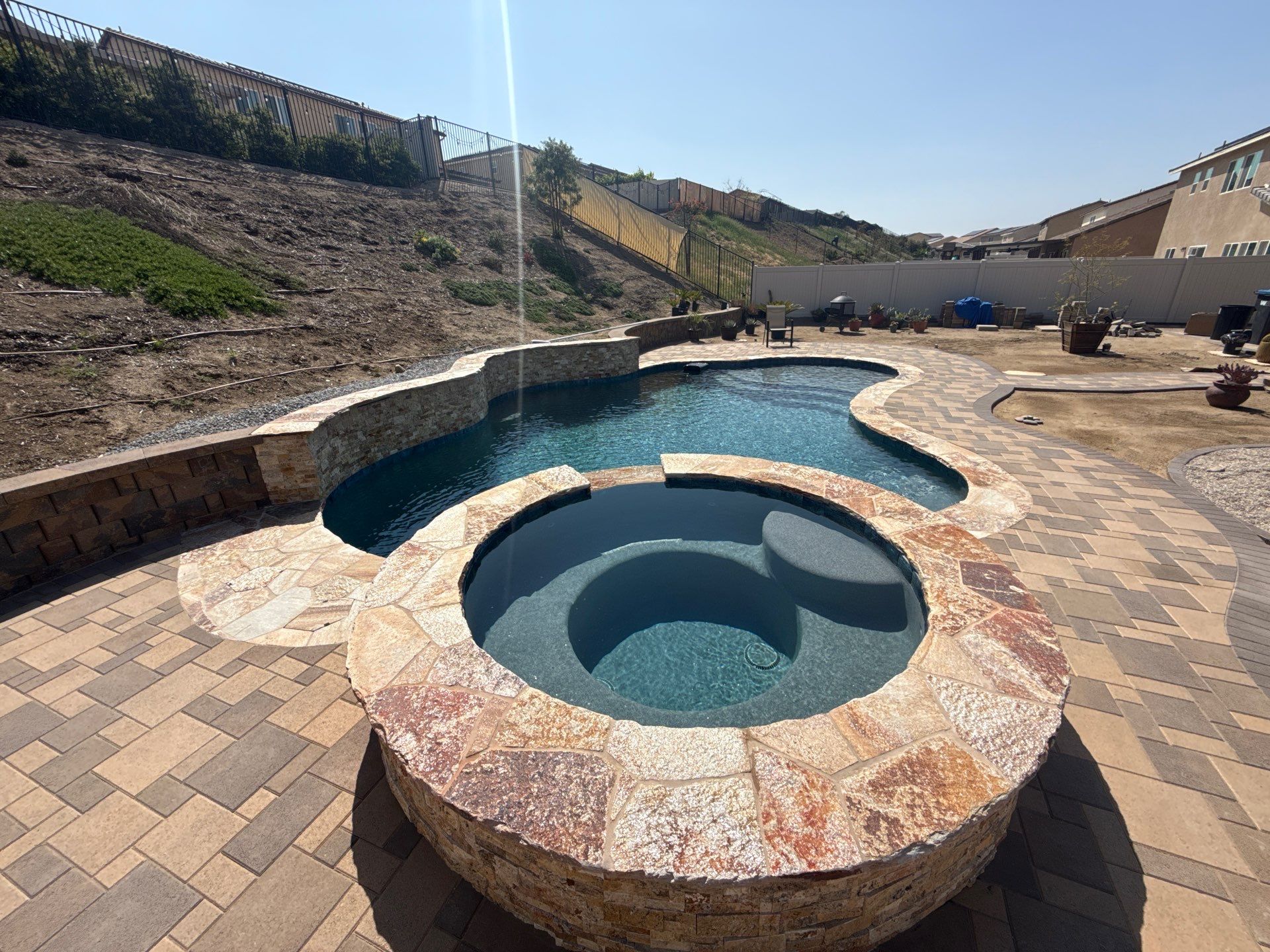 Freeform pool and spa with paver decking by Premier Pools and Spas Temecula