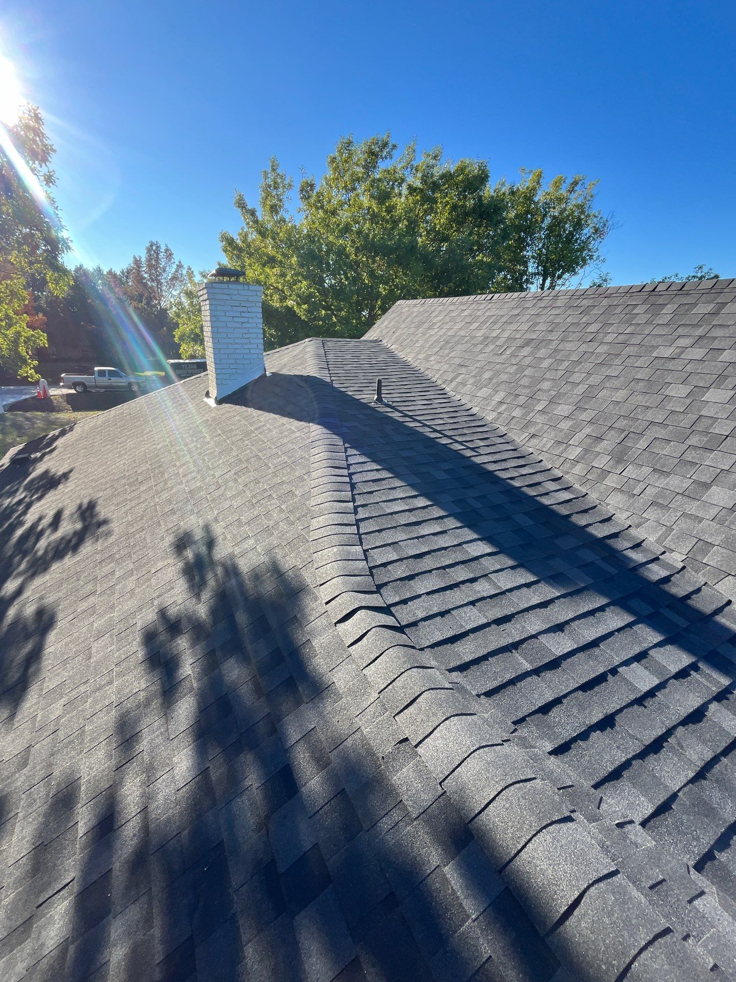 White brick with IKO Granite Black by Tejas Roofworks + Restoration