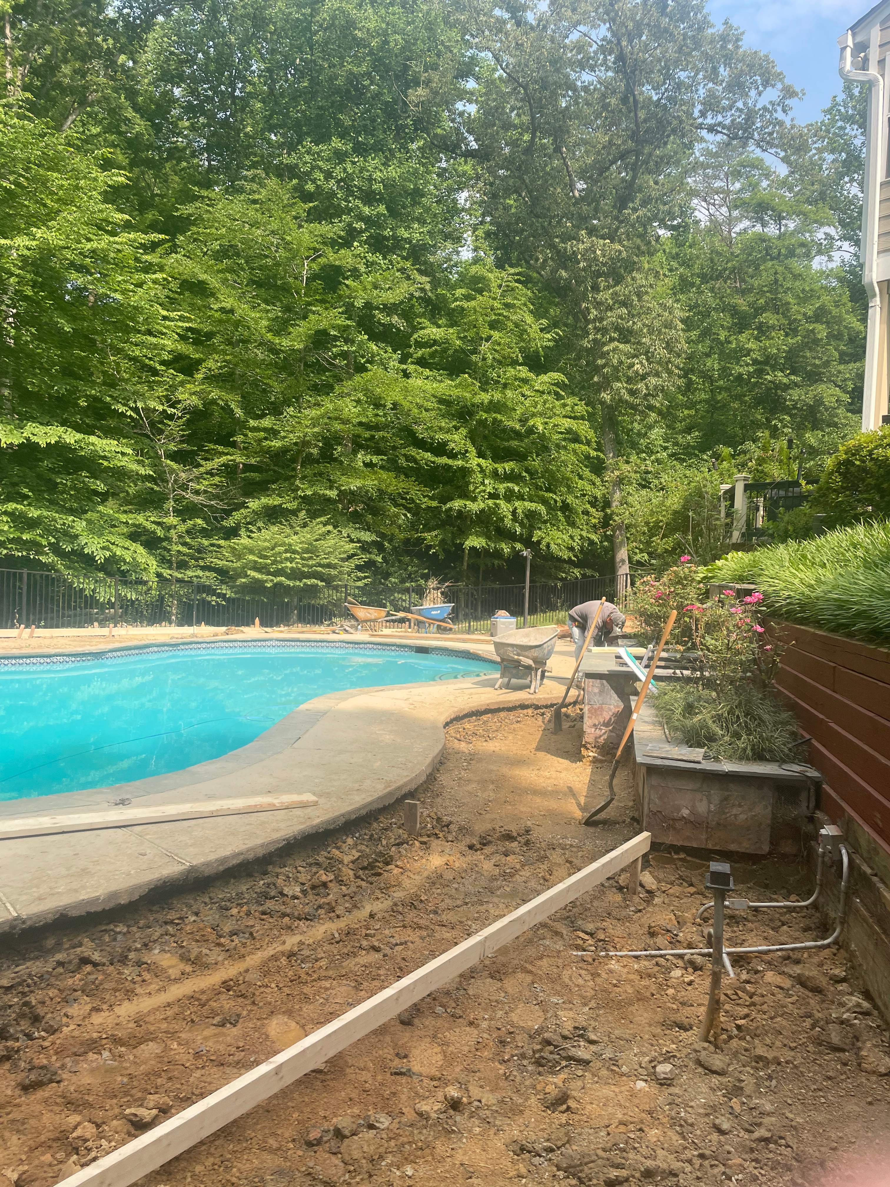 Pool Surround remodel with retaining walls, new waterfall and water slide by Fairfax Contractors, LLC