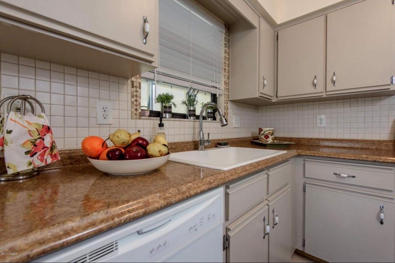 Modern Kitchen Remodel in Port Orange Featuring Waterfall Quartz Island by Acies Renovations