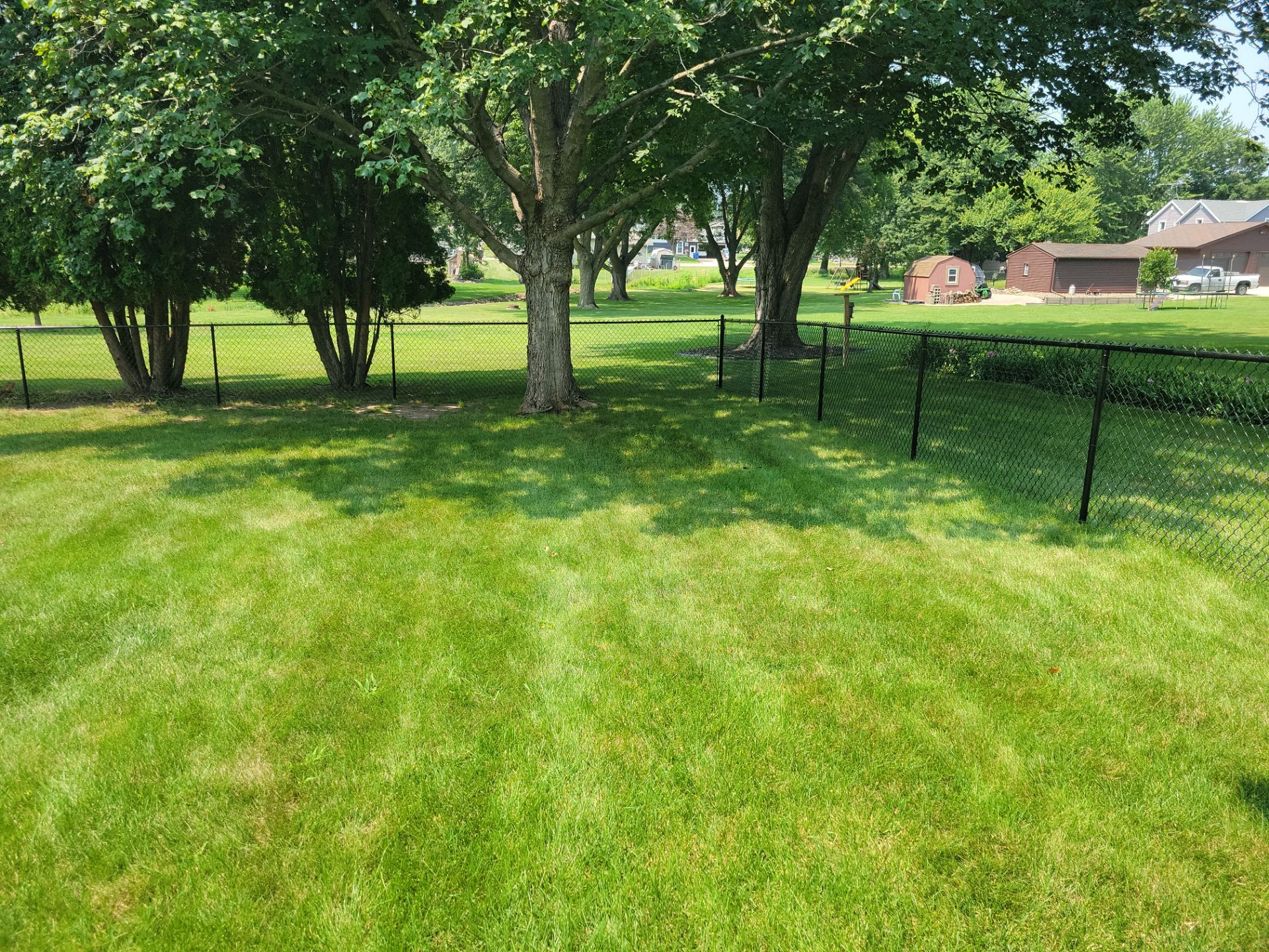 Black Vinyl-Coated Chain Link Fence Installation in New Hampton by Perfect Picket Fence and Stain