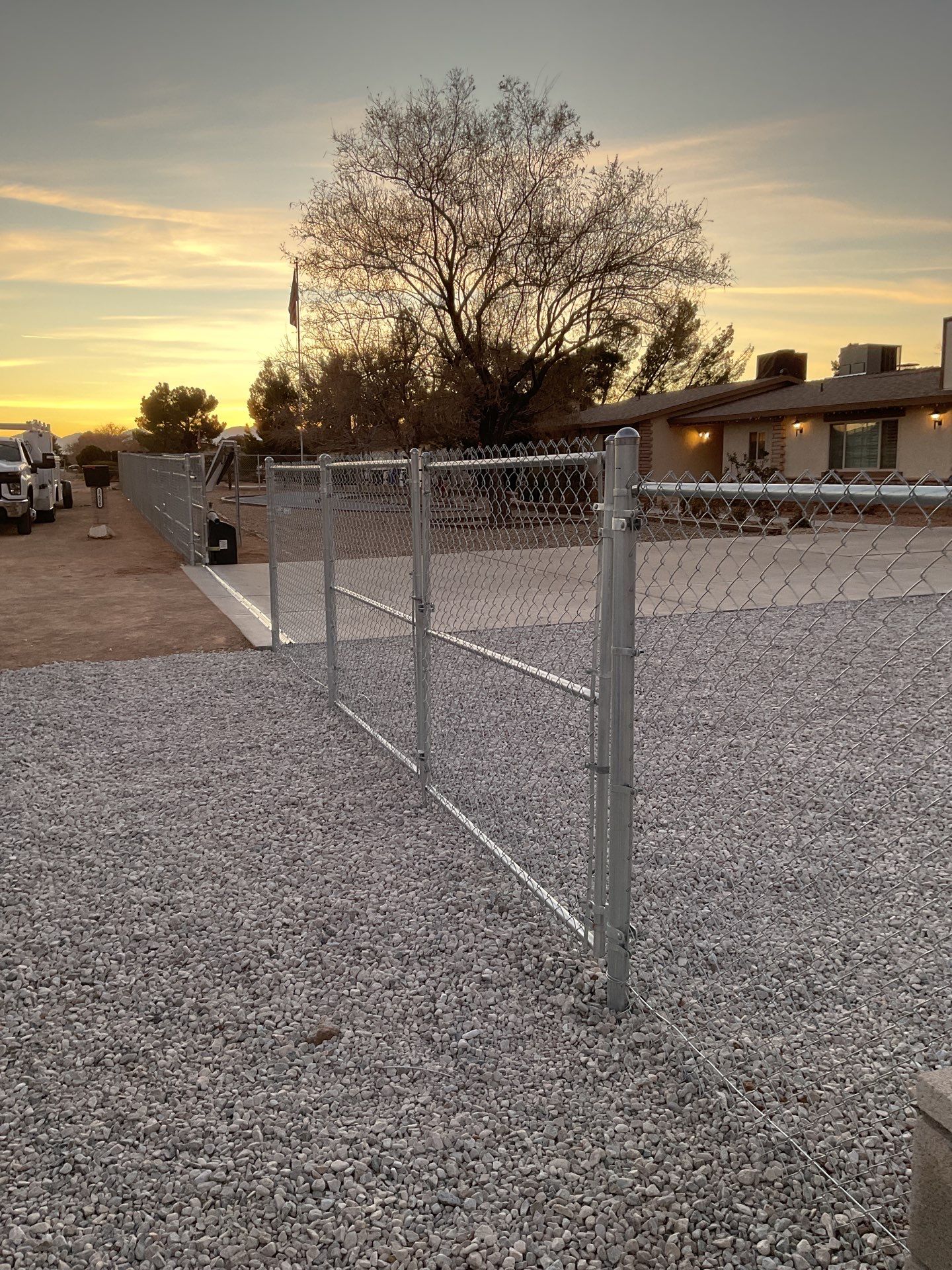 Sleek chain link fence installation with a solar motorized gate by Fence Guys Inc.