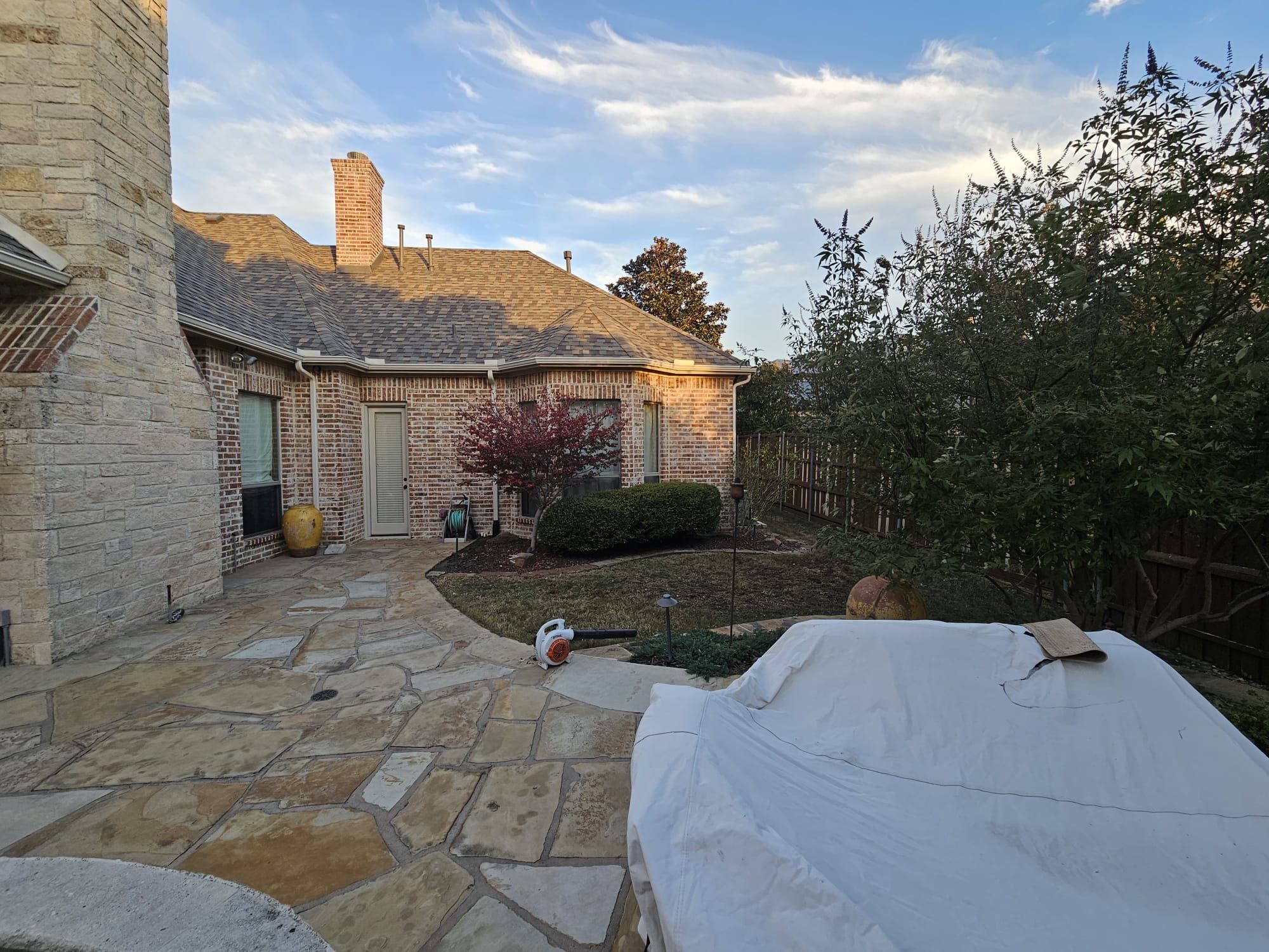 Light red brick/cream stone/espresso shutters with IKO Cornerstone by Tejas Roofworks + Restoration