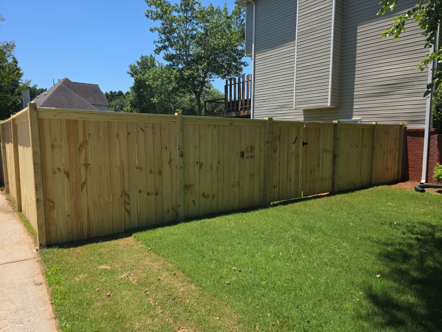 Fence Installation of a Capped Wood Privacy Fence by Titans of Timber Fence & Stain