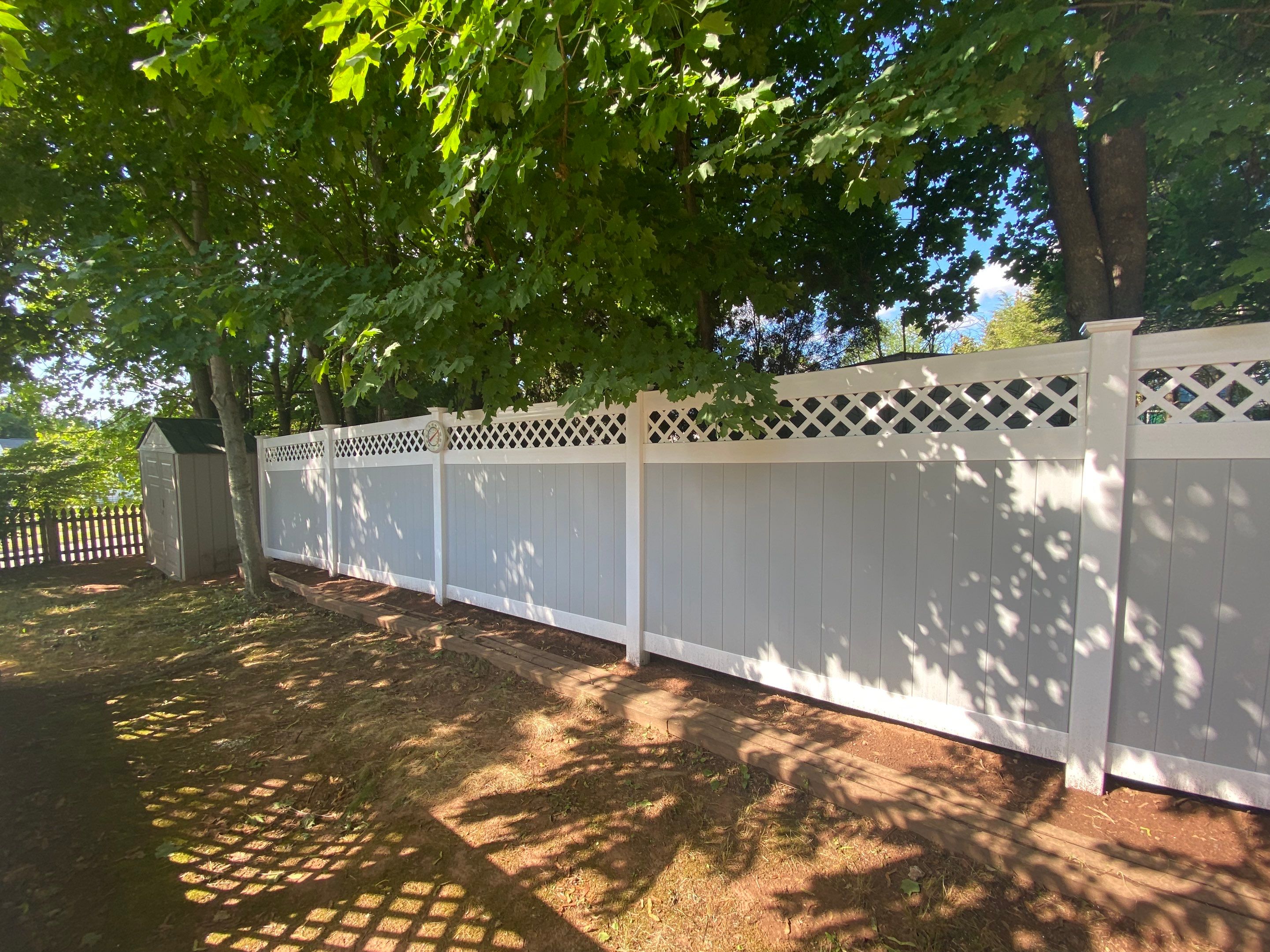 Vinyl privacy fence, Decorative lattice top. Two toned coloring White and Gray by DiGiorgi Roofing and Siding Inc