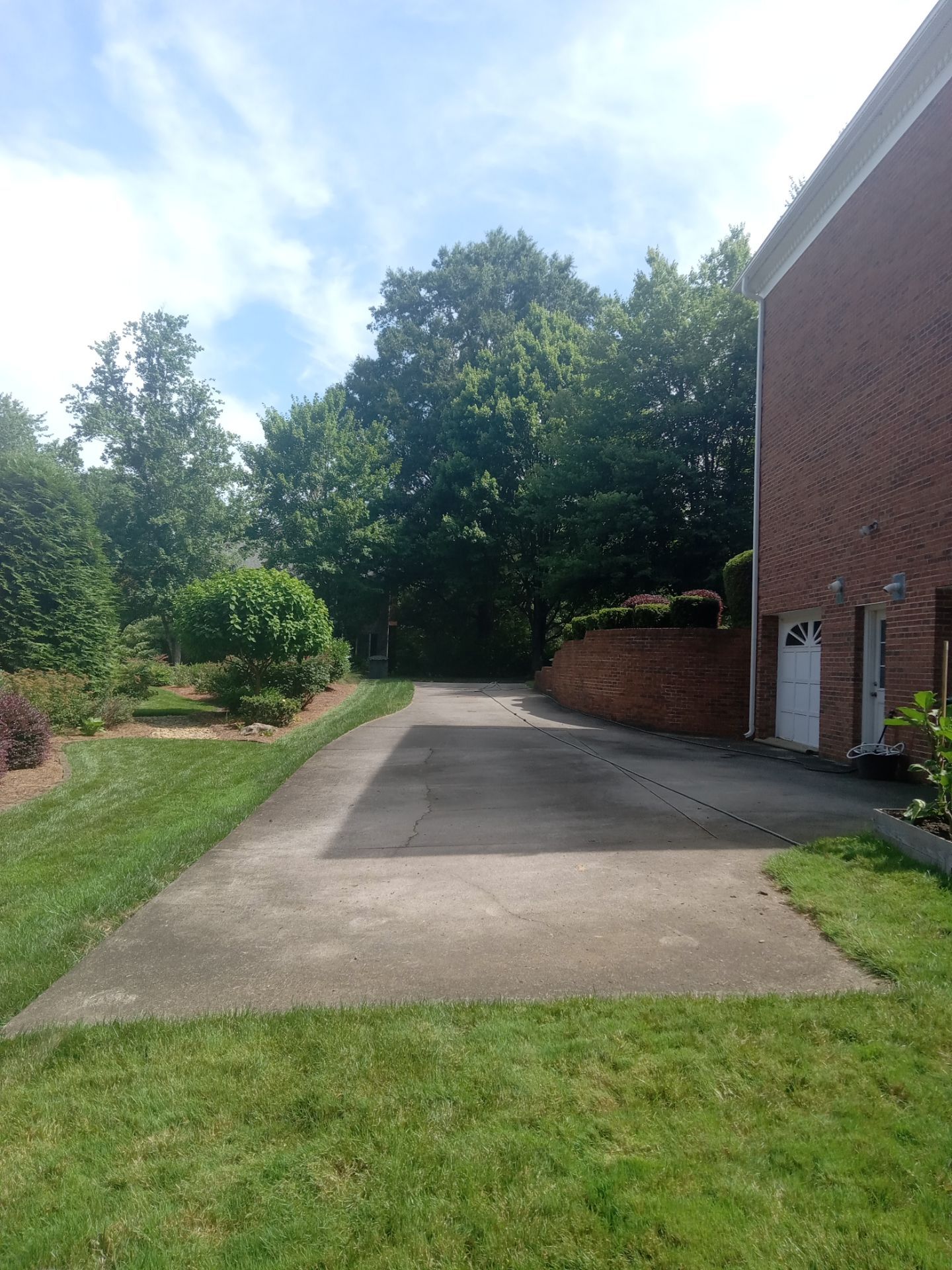 pressure washing driveway and walkways removing dirt buildup and stains restoring clean appearance of concrete surfaces