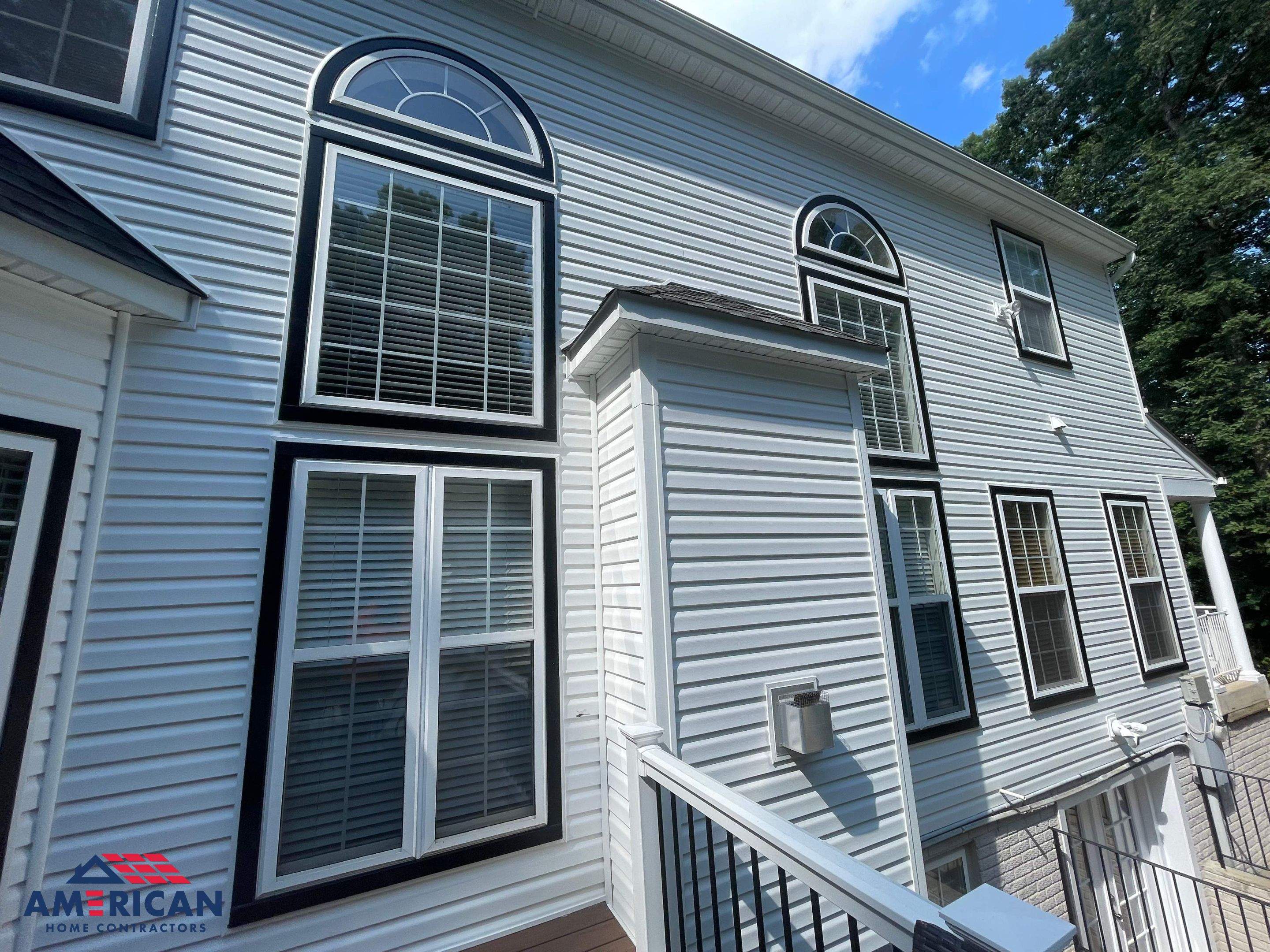Vinyl Siding Replacement + Black Trim by American Home Contractors