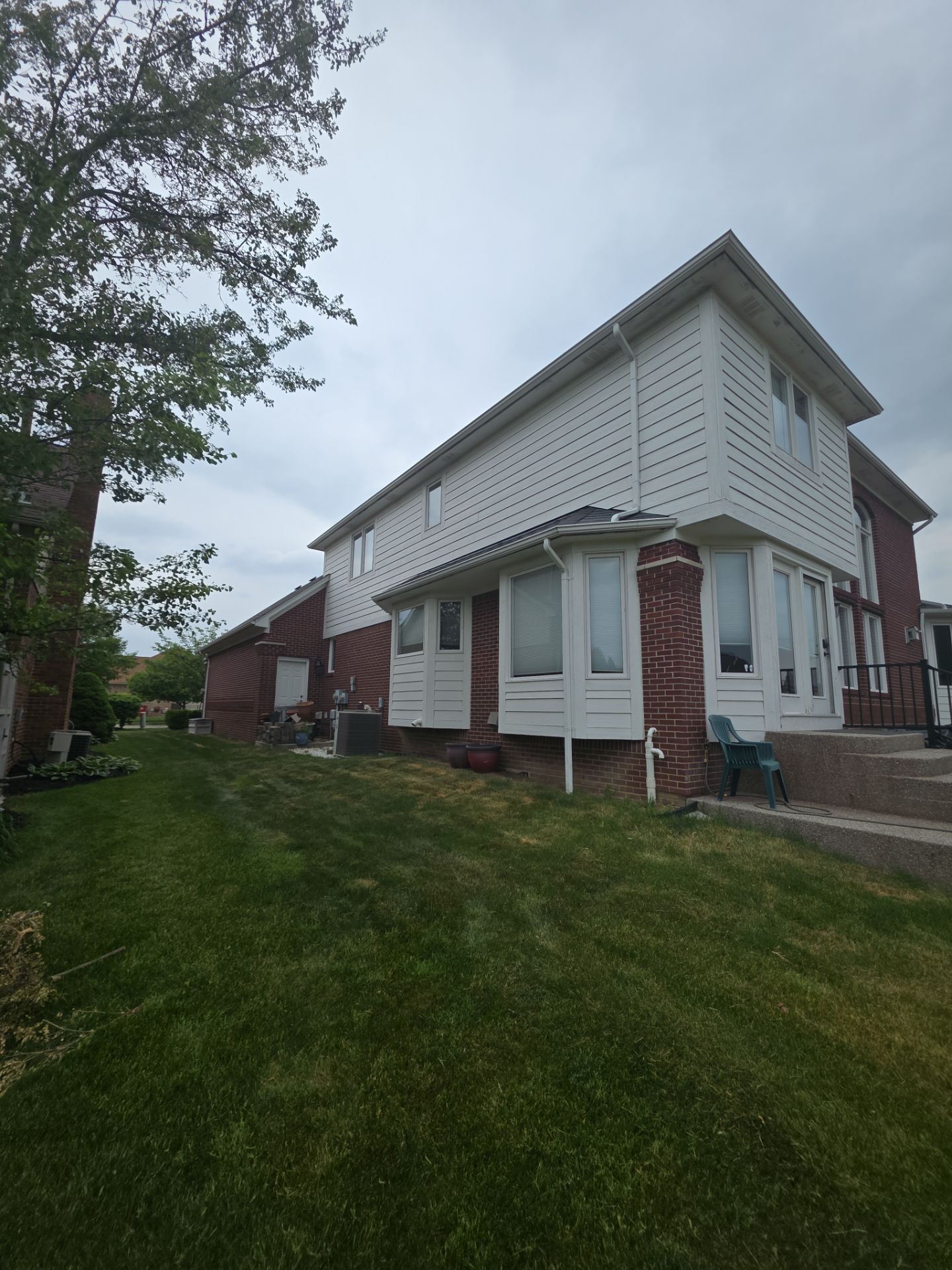 Siding and Trim Repair and Exterior Painting for a Macomb Brick Residence by Top Shelf Painter