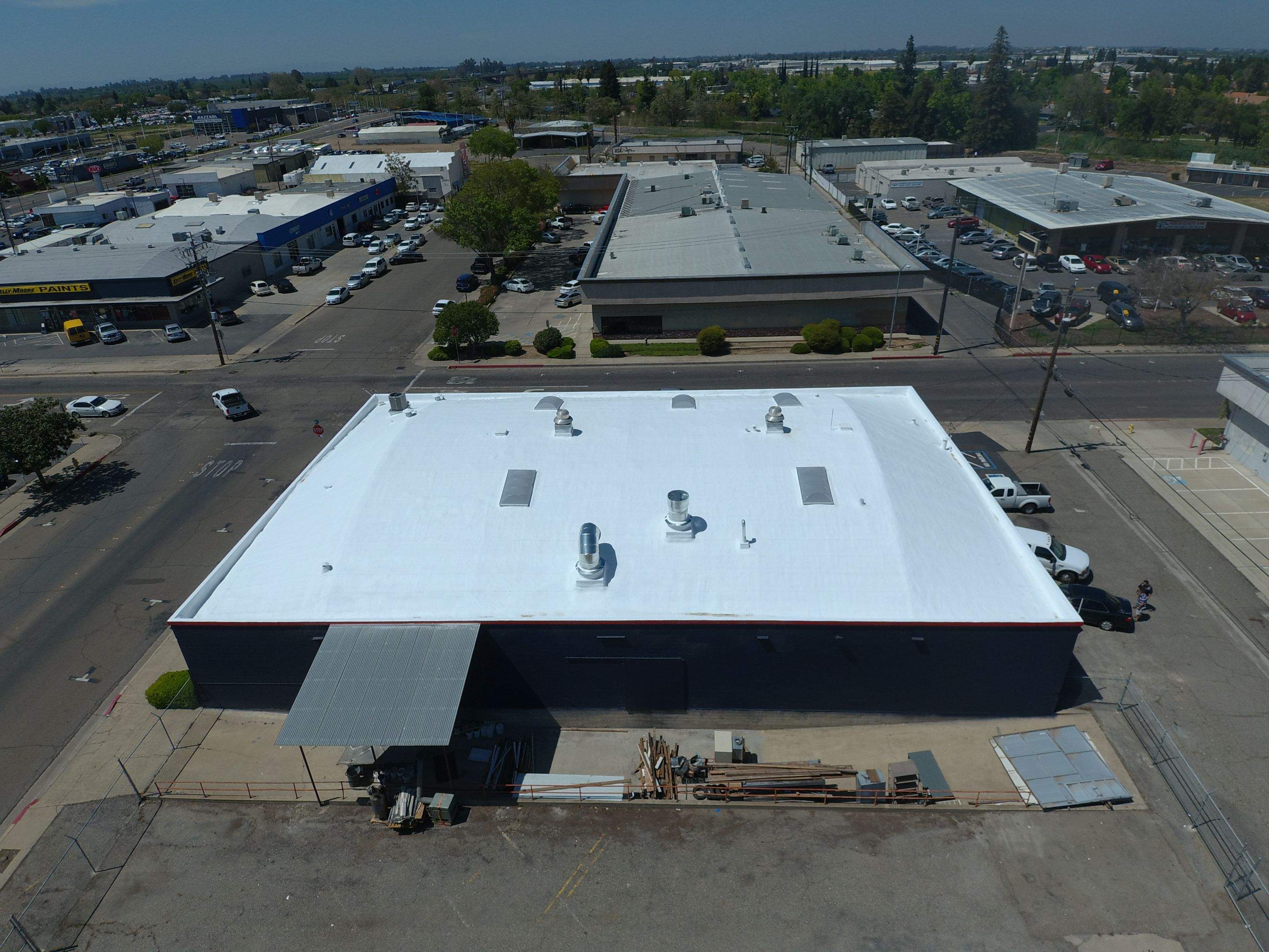 Spray foam and coatings using Conklin Benchmark/PUMA XL coatings on Auto Body Shop by Straight Edge Roofing Inc