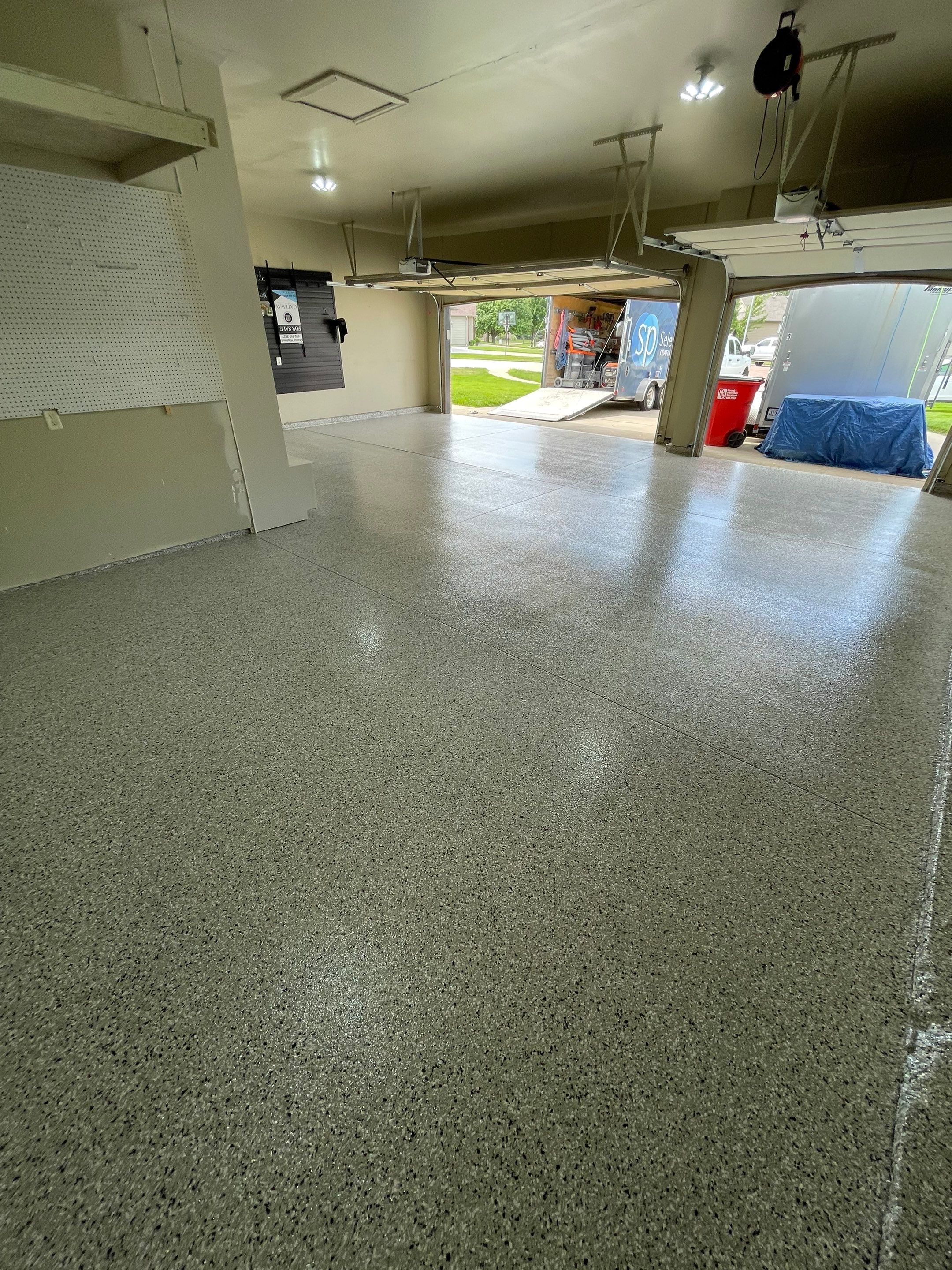 Cabin FEver Flake Garage Floor Coating Installation in Sioux Falls by Select Painting, Coatings & Garage Cabinets
