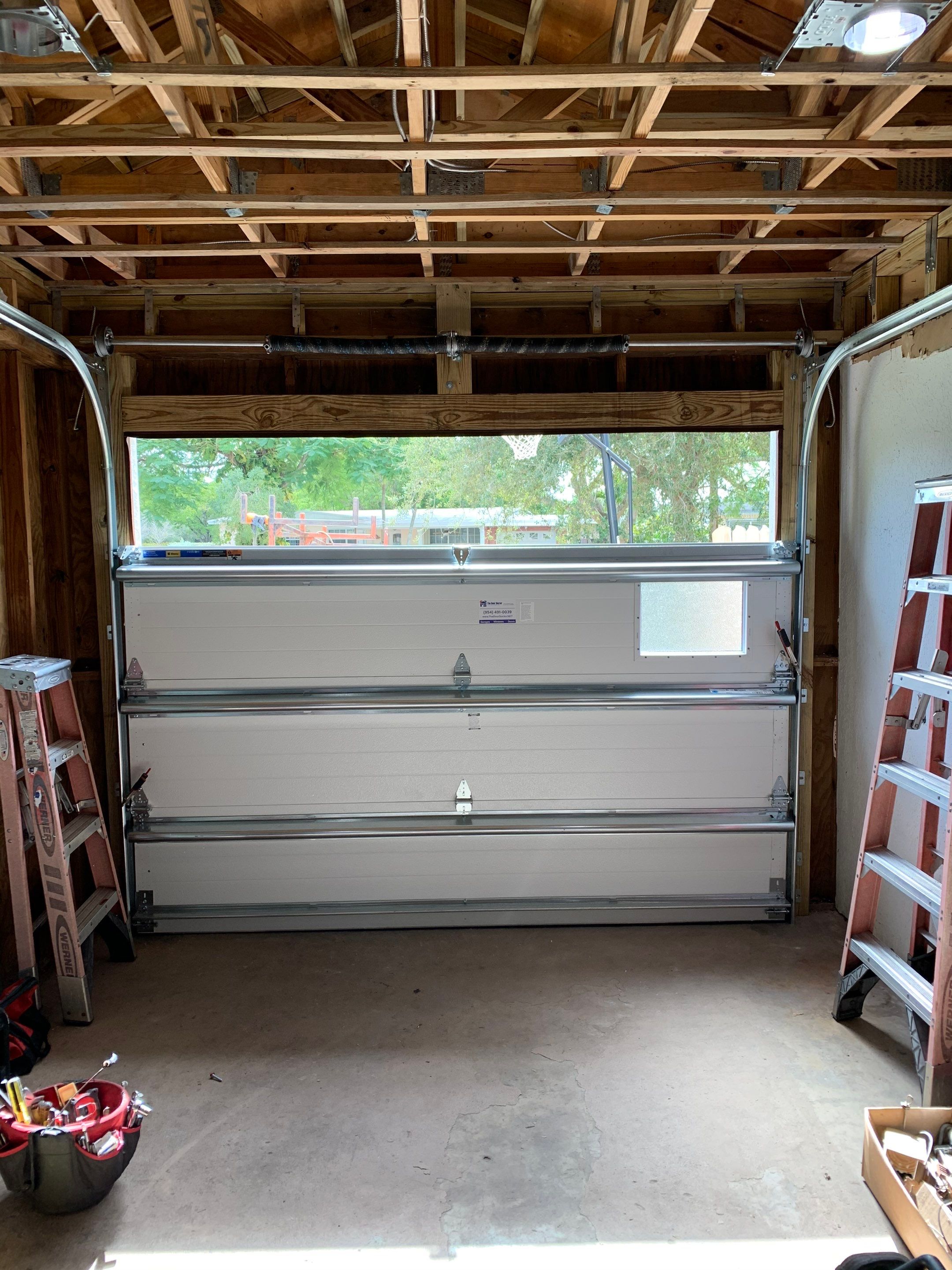 Sectional Garage Door Installation with Wood-Grain Finish in Sunrise - Clopay Modern Steel by The Door Doctor of South Florida, Inc.
