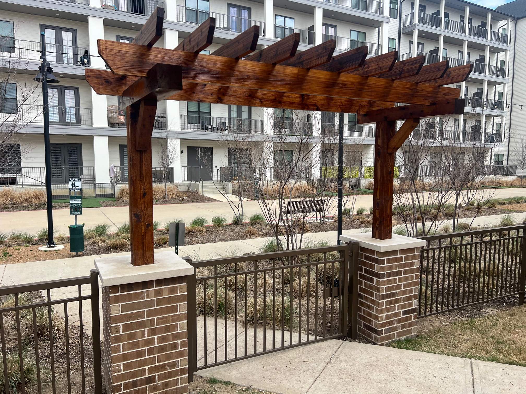 Arbor with Wrought Iron Fencing by 3:16 Roofing and Construction