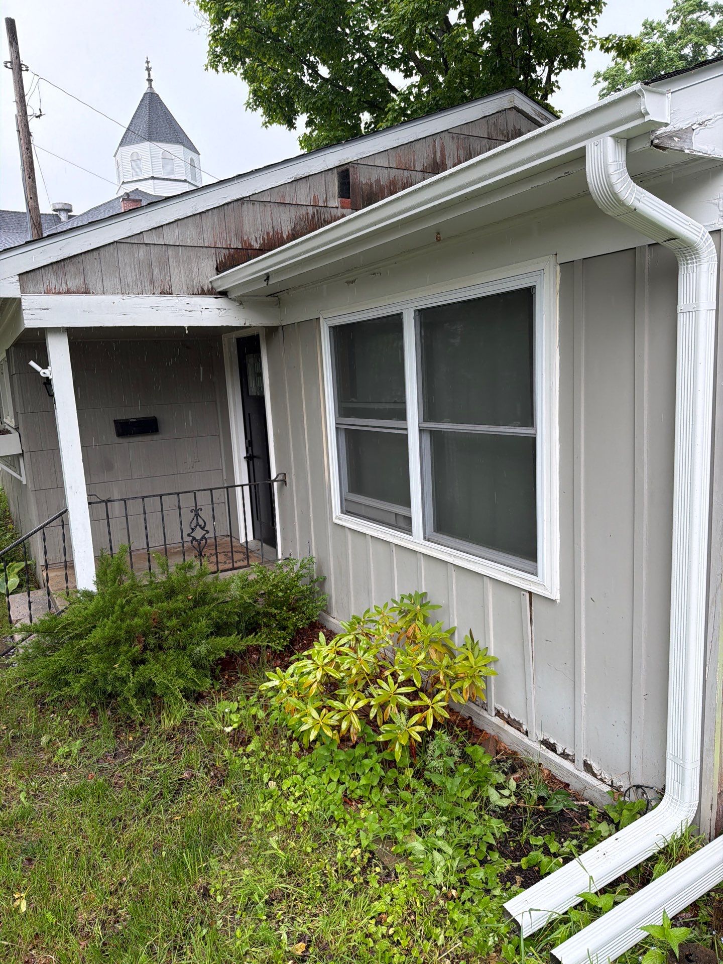 White Gutter and Downspout System Installation in Petoskey by Rainbow Seamless Systems