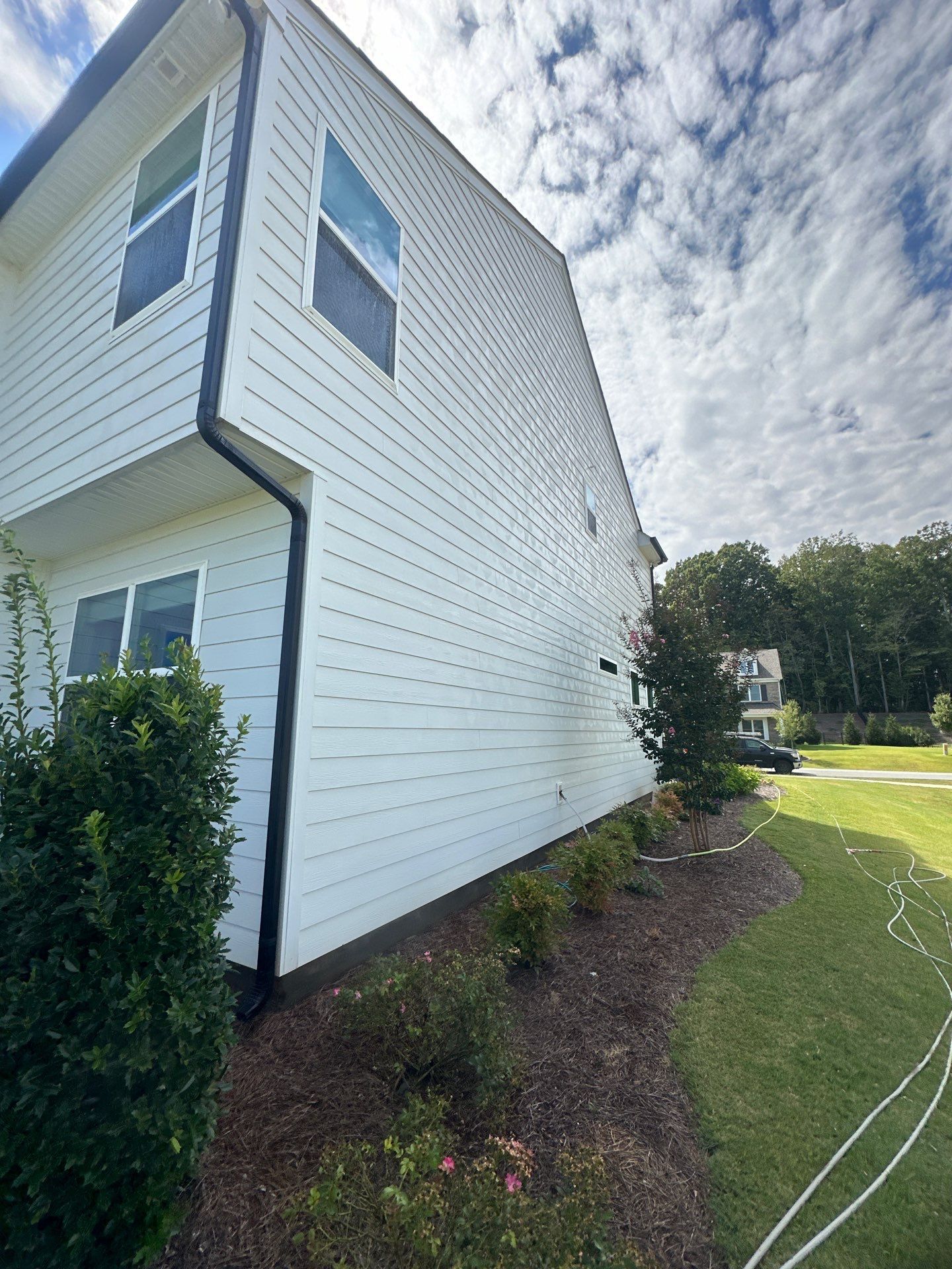 the service being done is cleaning the exterior siding of a house using pressure washing techniques