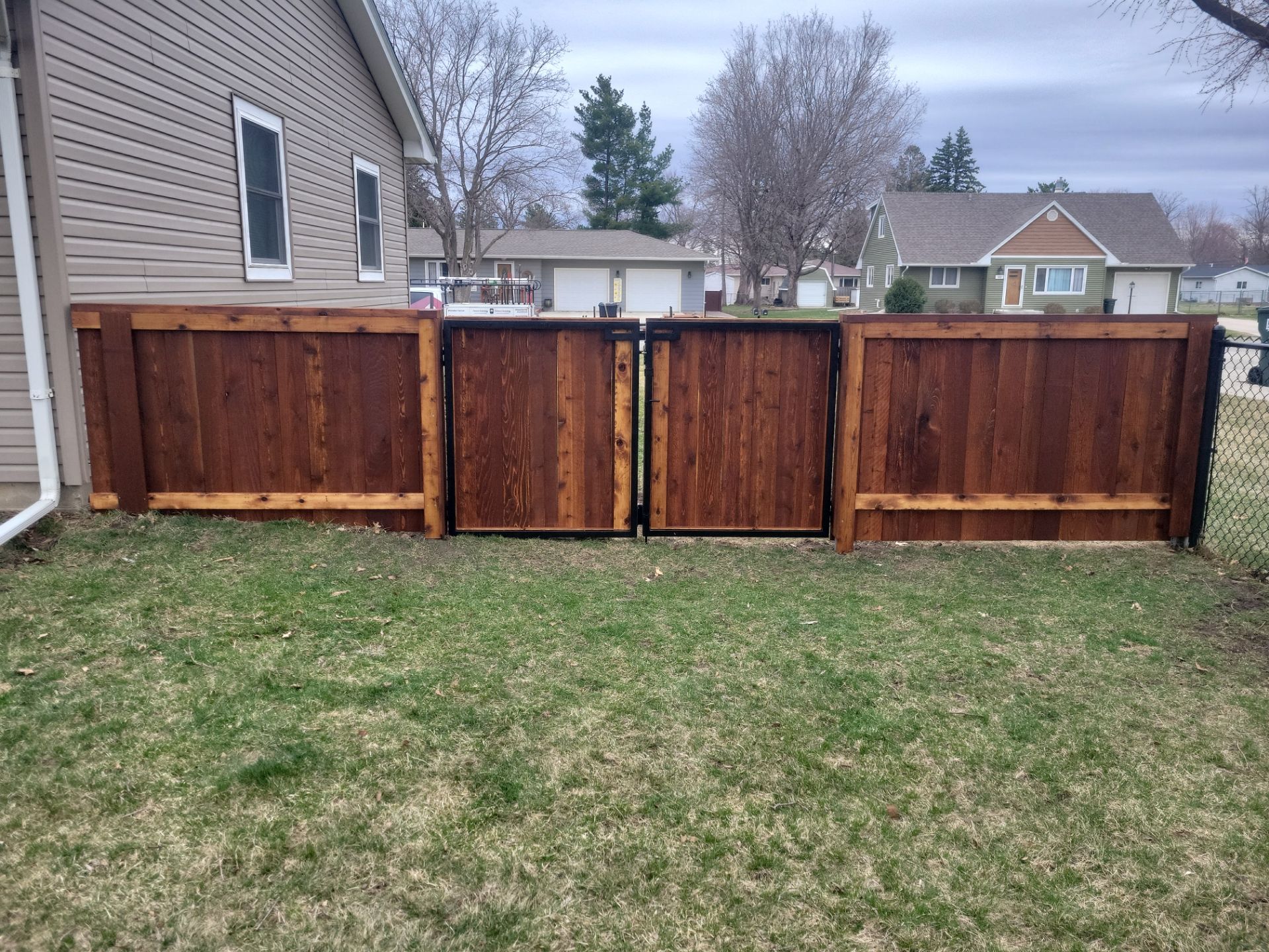 Dark Stained Cedar Privacy Fence and Custom Gates in Cedar Falls by Perfect Picket Fence and Stain