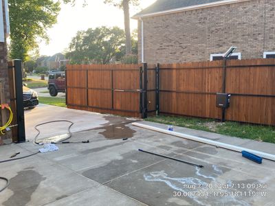 Complete metal driveway gate install with solar powered opener. Metal fence frame with Cedar Pickets
