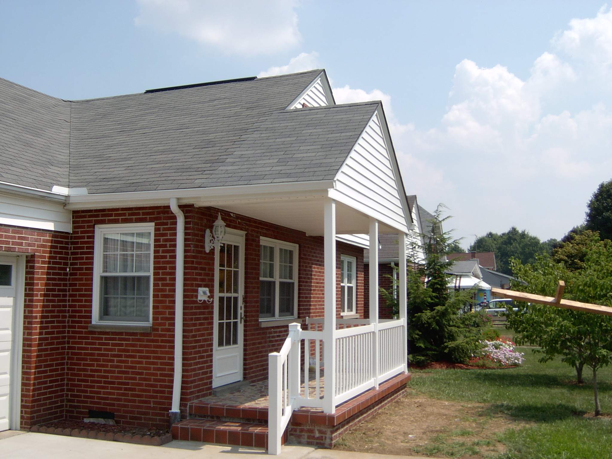 New front porch build, with tile floor and vinyl railing. by Secure Construction Company Inc