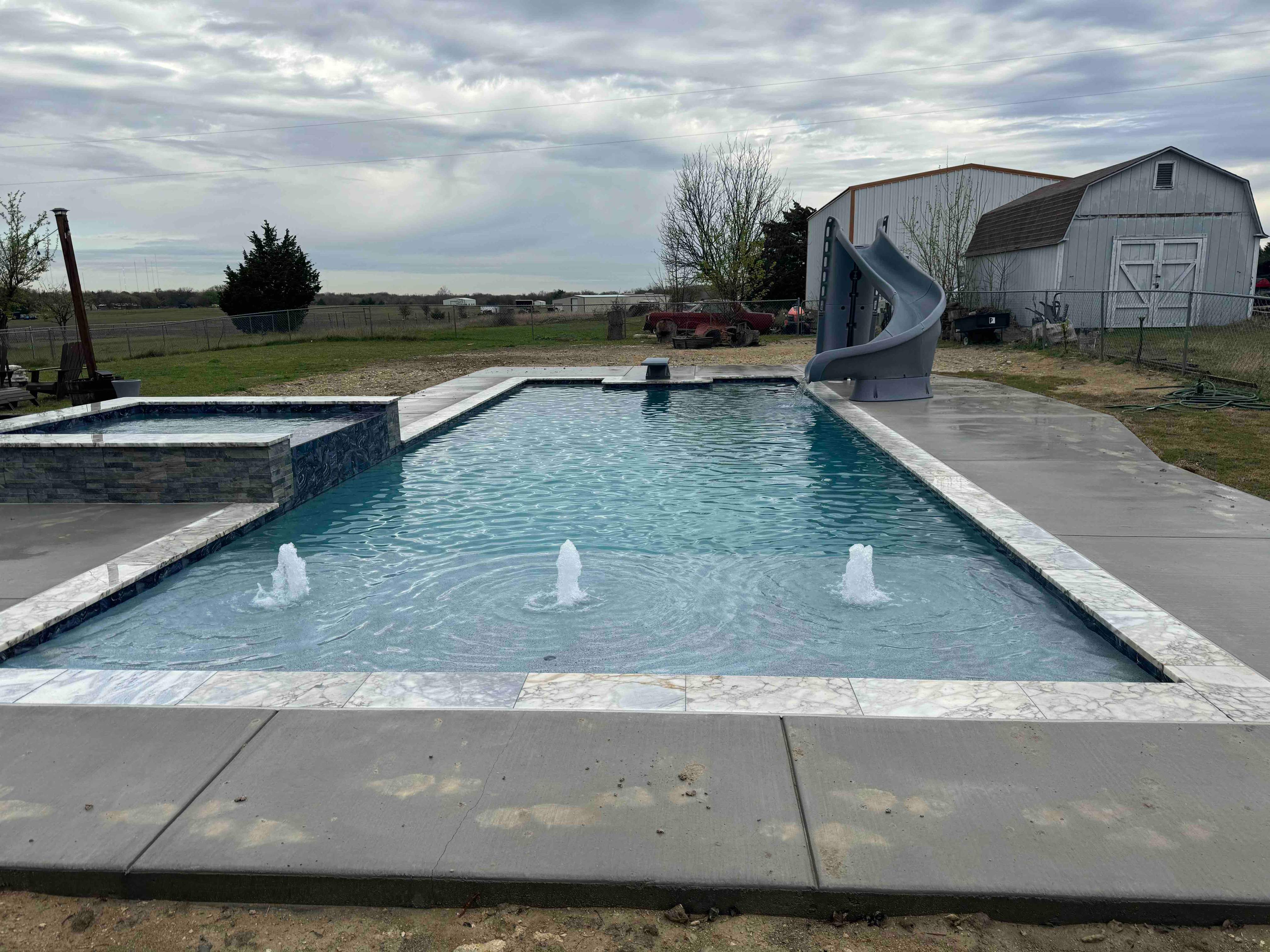 Geometric Pool with Beach Entry, Slide and Raised Spa by Pinnacle Pools and Spas - DFW