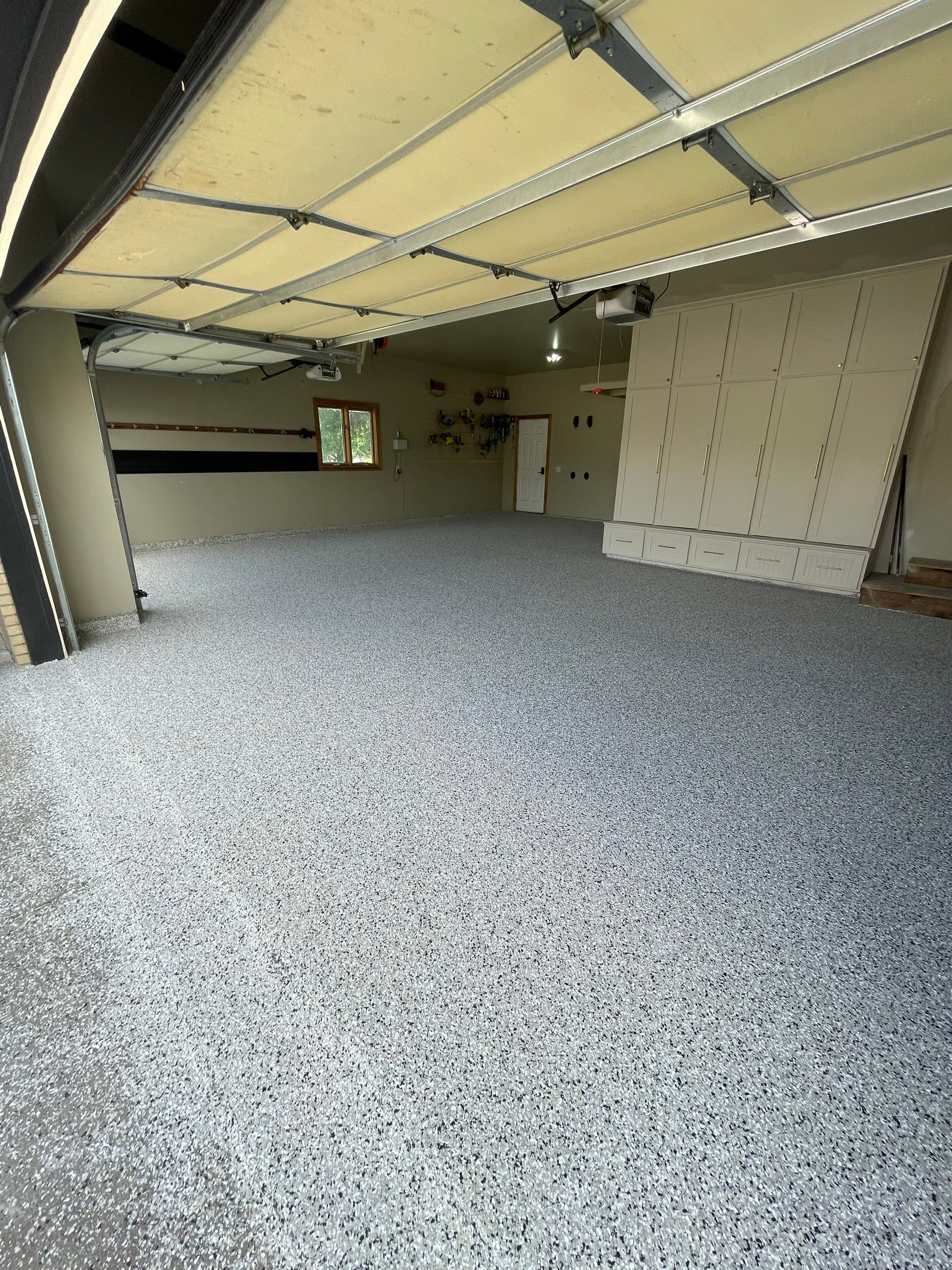 Cabin FEver Flake Garage Floor Coating Installation in Sioux Falls by Select Painting, Coatings & Garage Cabinets